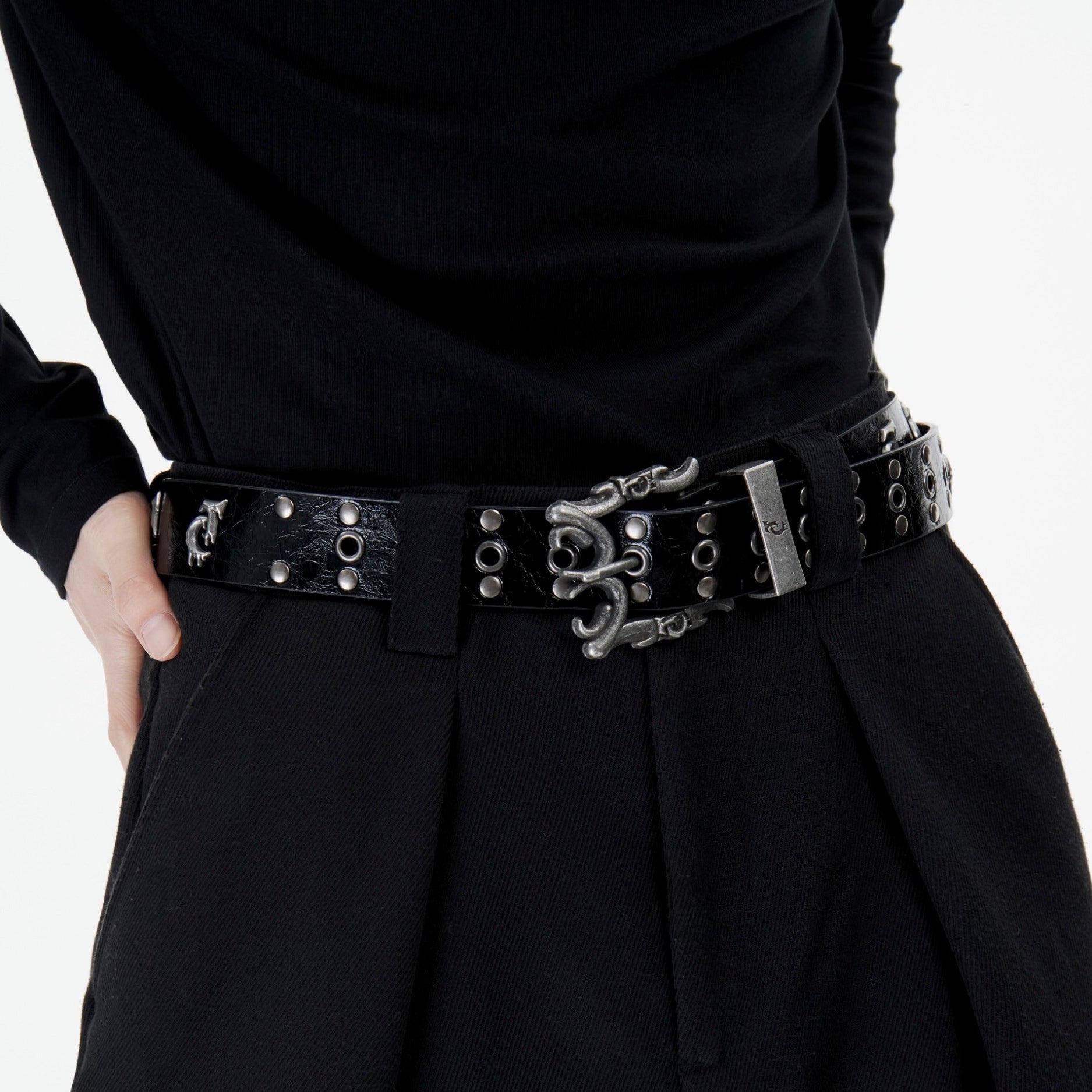 Fashion model wearing distressed metal logo belt with urban streetwear outfit