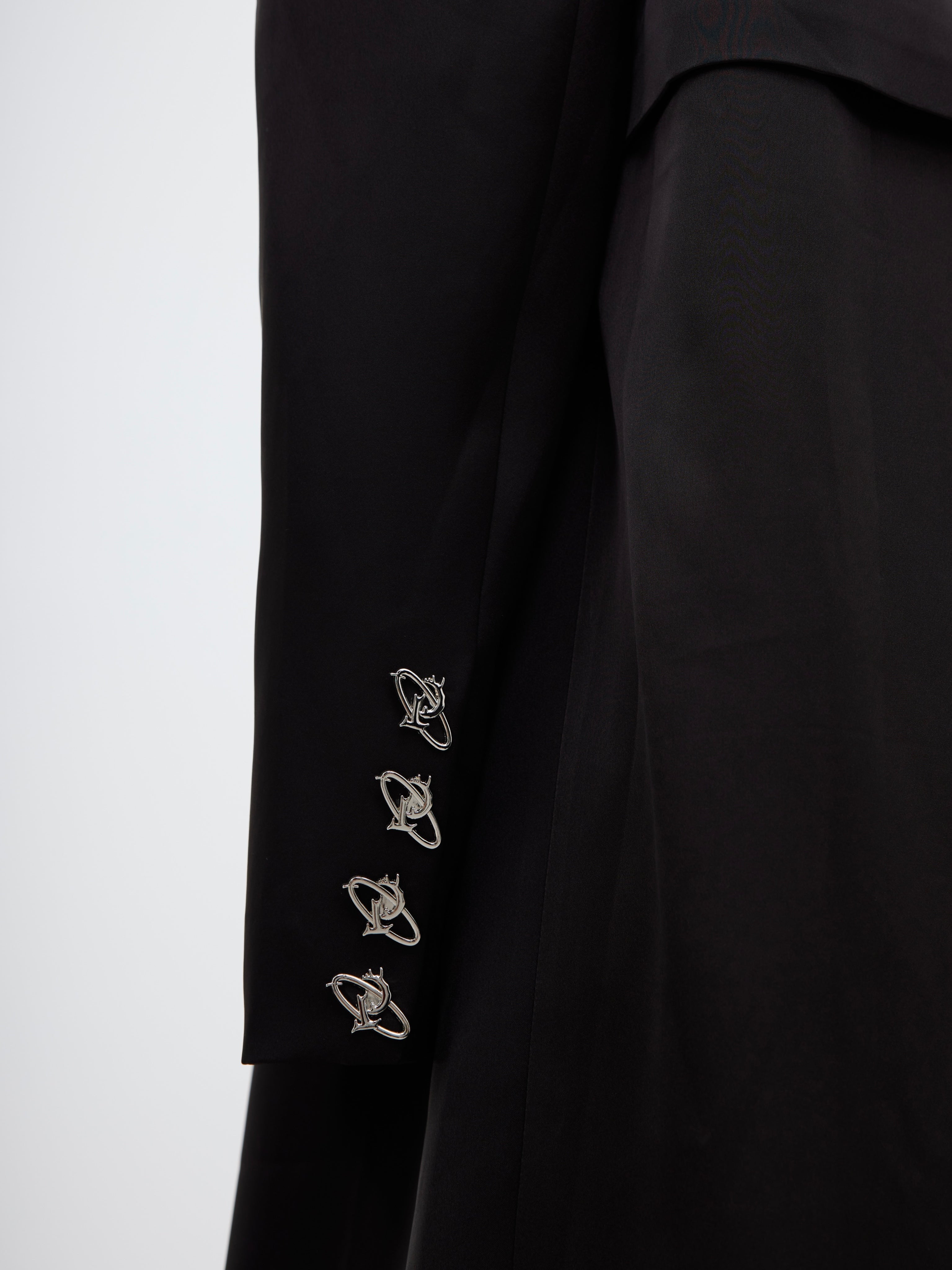 Stylish asymmetric cut deconstructed trench coat with modern streetwear aesthetic and metallic hardware