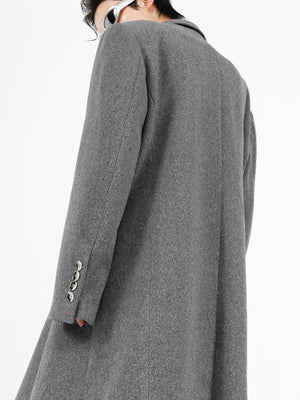 Front view of deconstructed wool coat showing structured shoulder pads and strategic slit detailing for edgy street style