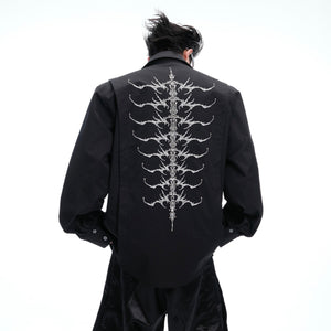Model wearing embroidered studded spine shirt showing front design of this unique streetwear piece