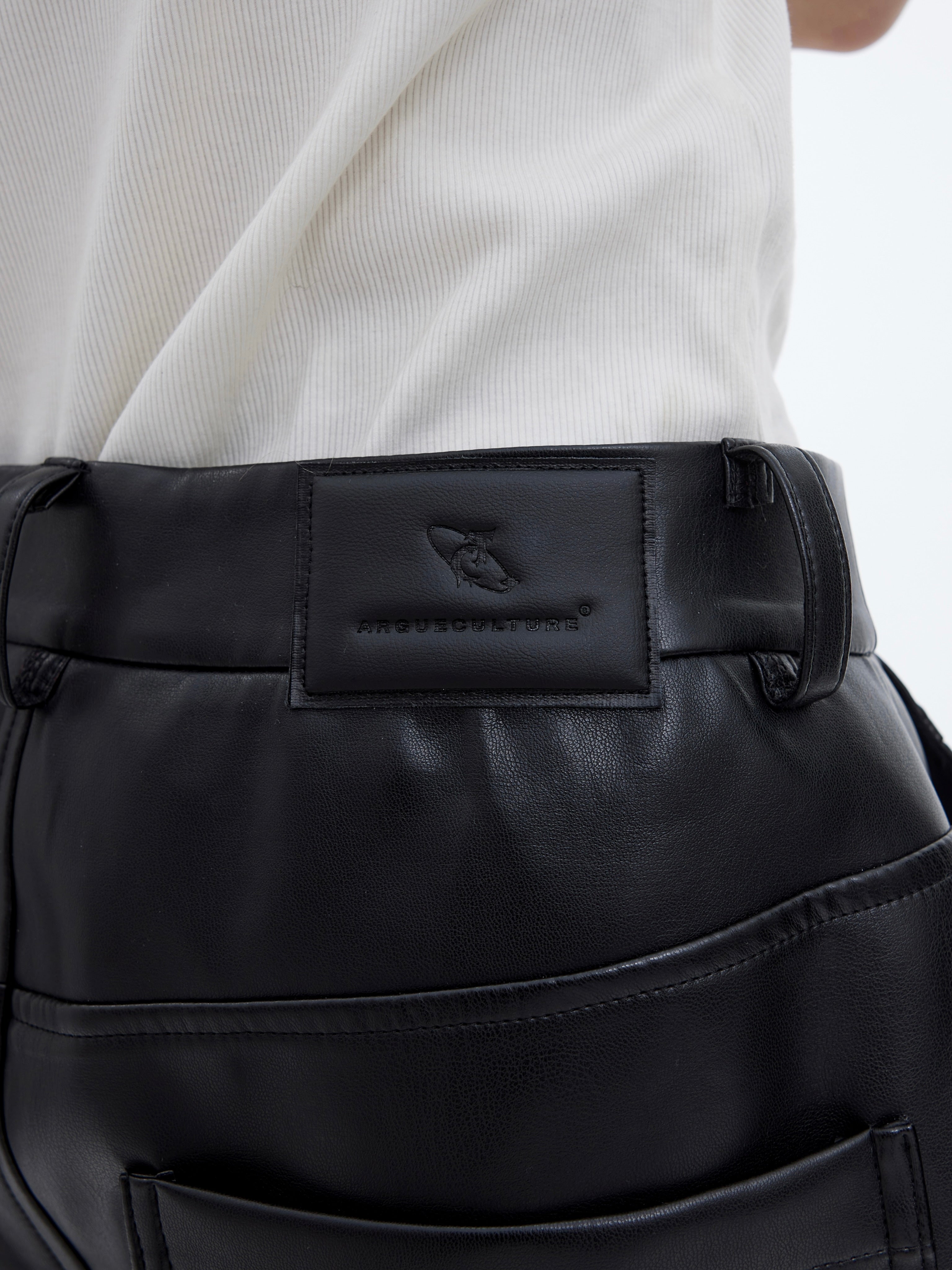 Close-up detail of the matte leather pants showing texture, distressed effects and quality craftsmanship