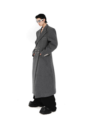Close-up of statement metal airplane buckle clasp on avant-garde deconstructed wool long jacket