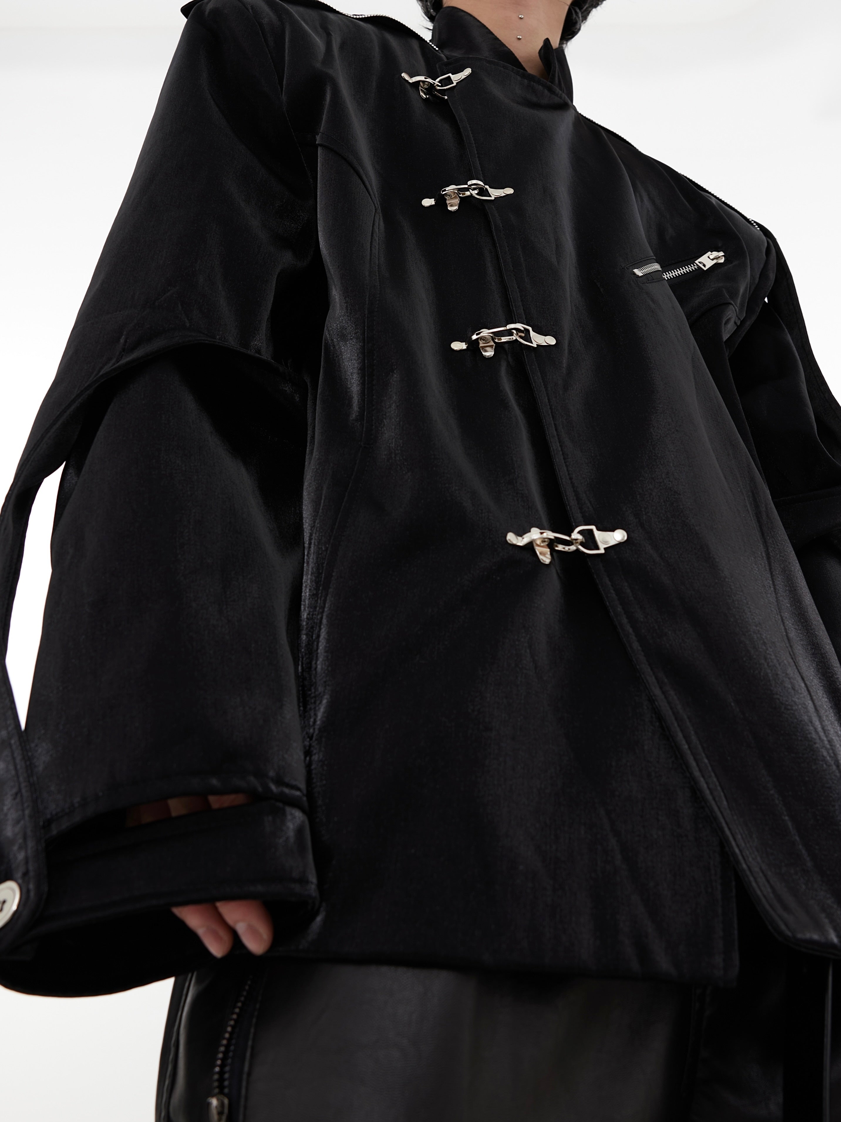 Close-up of decorative metal clasps on premium mandarin collar blazer with liquid-effect fabric