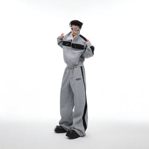 Front view of drop-shoulder cropped hoodie with metal stud details, paired with matching joggers for urban streetwear look