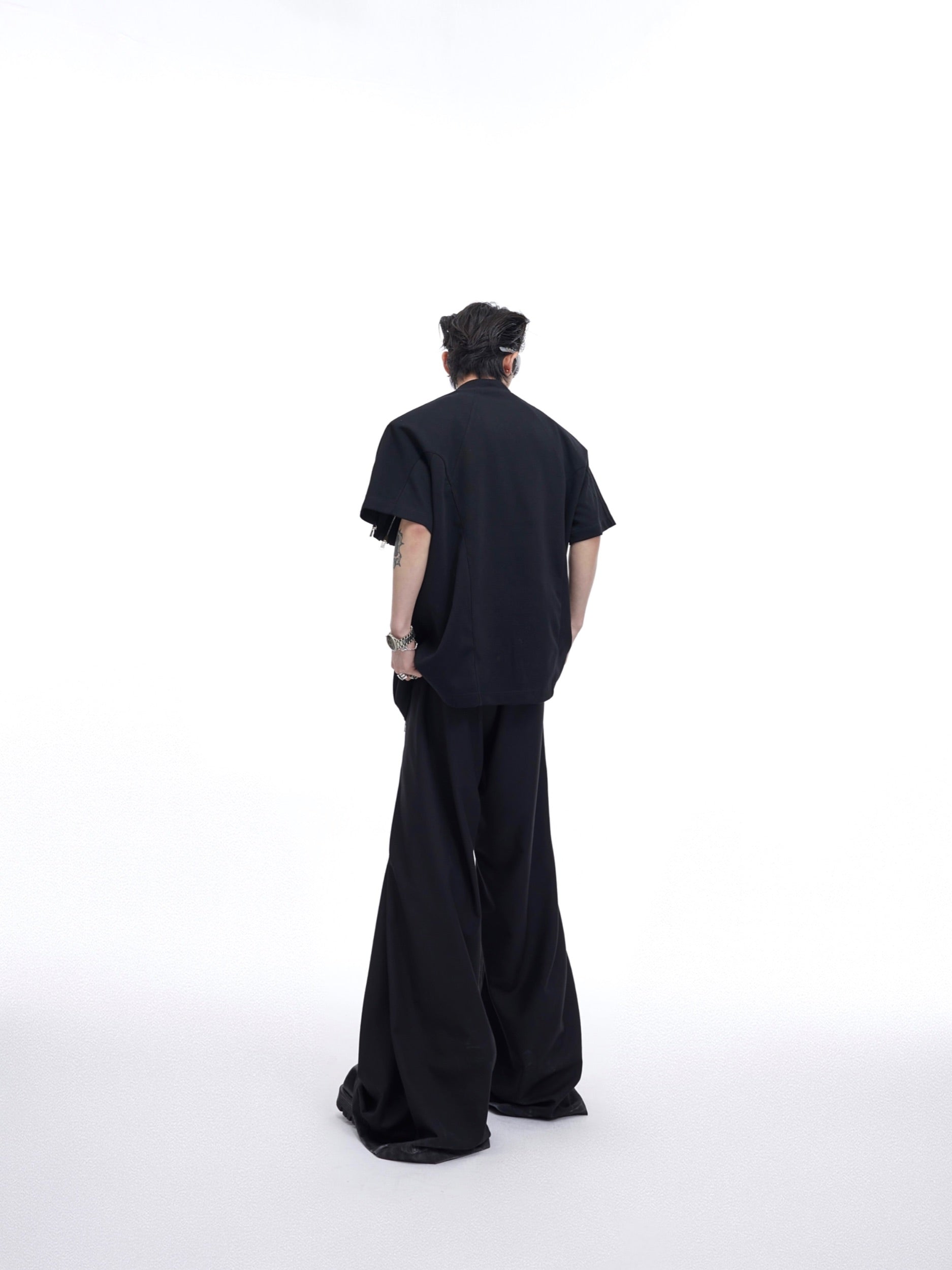 Back view of textured streetwear top featuring prominent metal zipper design and deconstructed tailoring