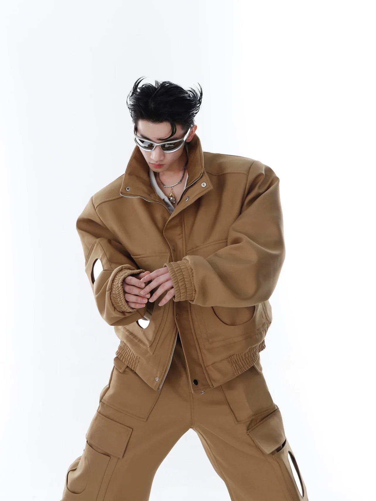Front view of avant-garde cropped jacket with mirror panels and oversized pockets, modern streetwear fashion