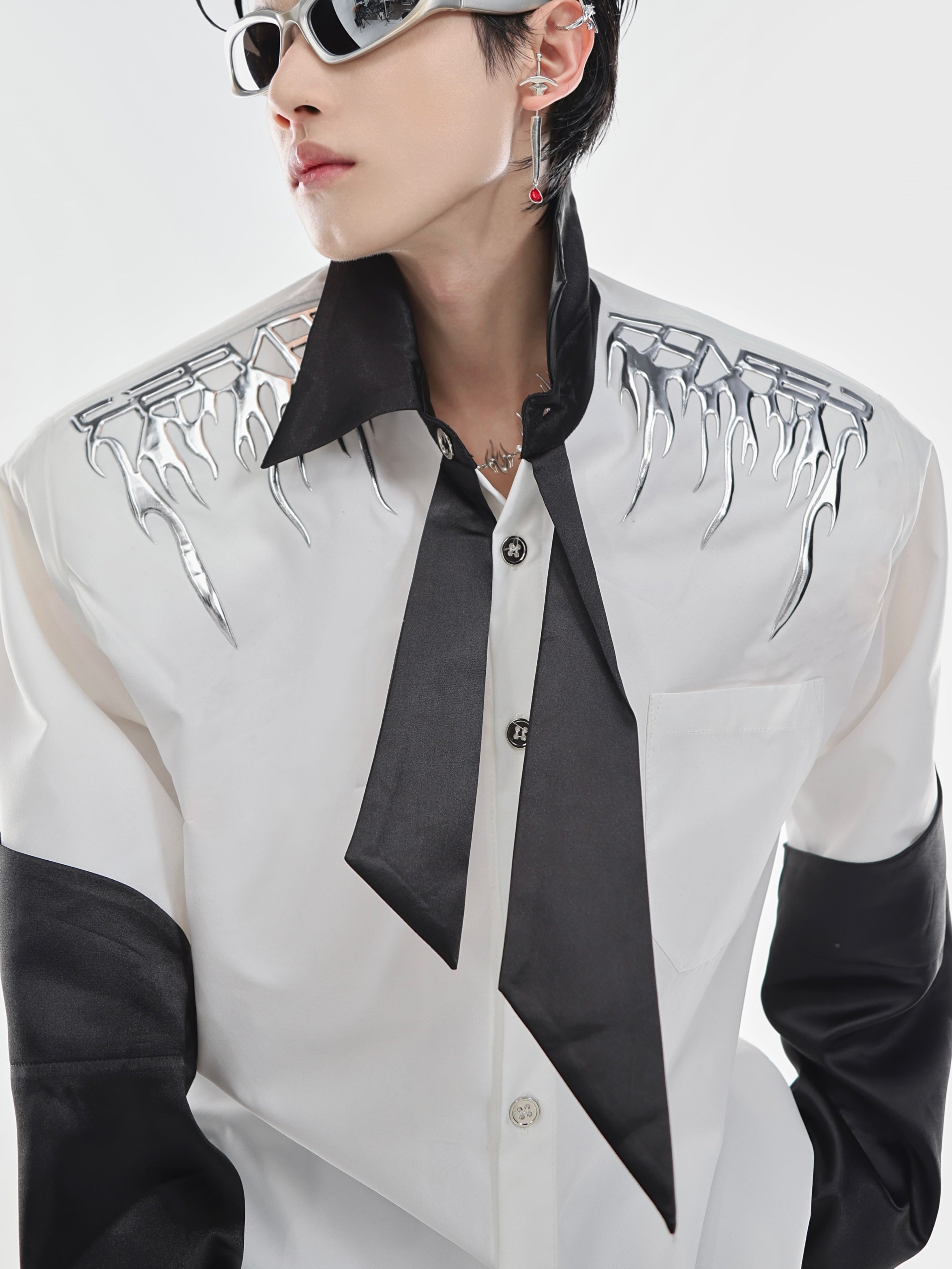 Close-up of the built-in diagonal necktie detail on this oversized streetwear shirt with contrast color blocking
