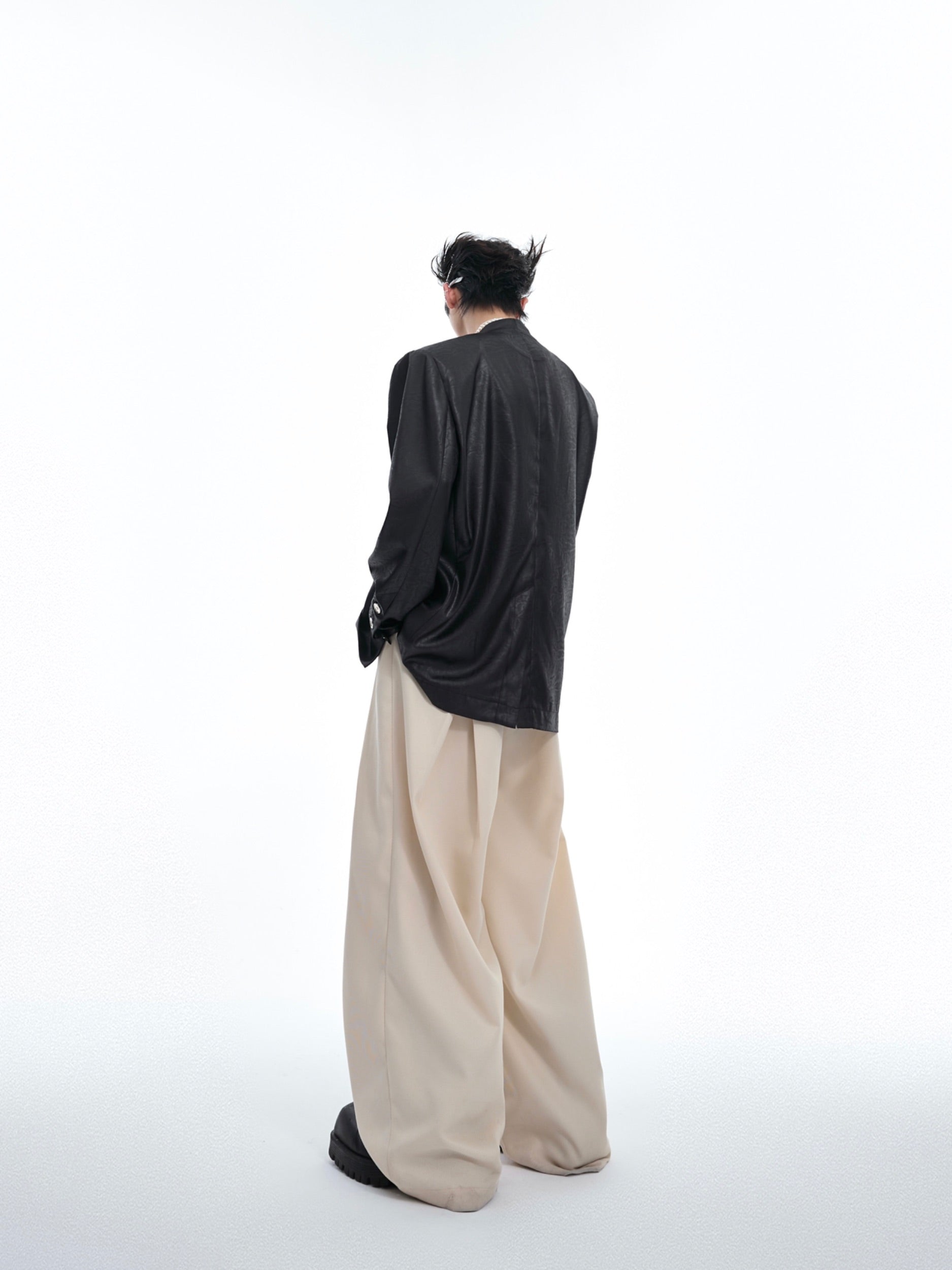 Folded view showcasing the unique liquid metal texture and oversized fit of this contemporary blazer