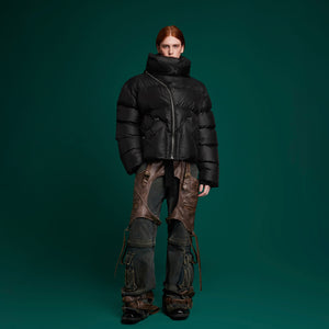 Close-up of the signature logo and premium metal diagonal zipper on heavyweight cotton puffer coat