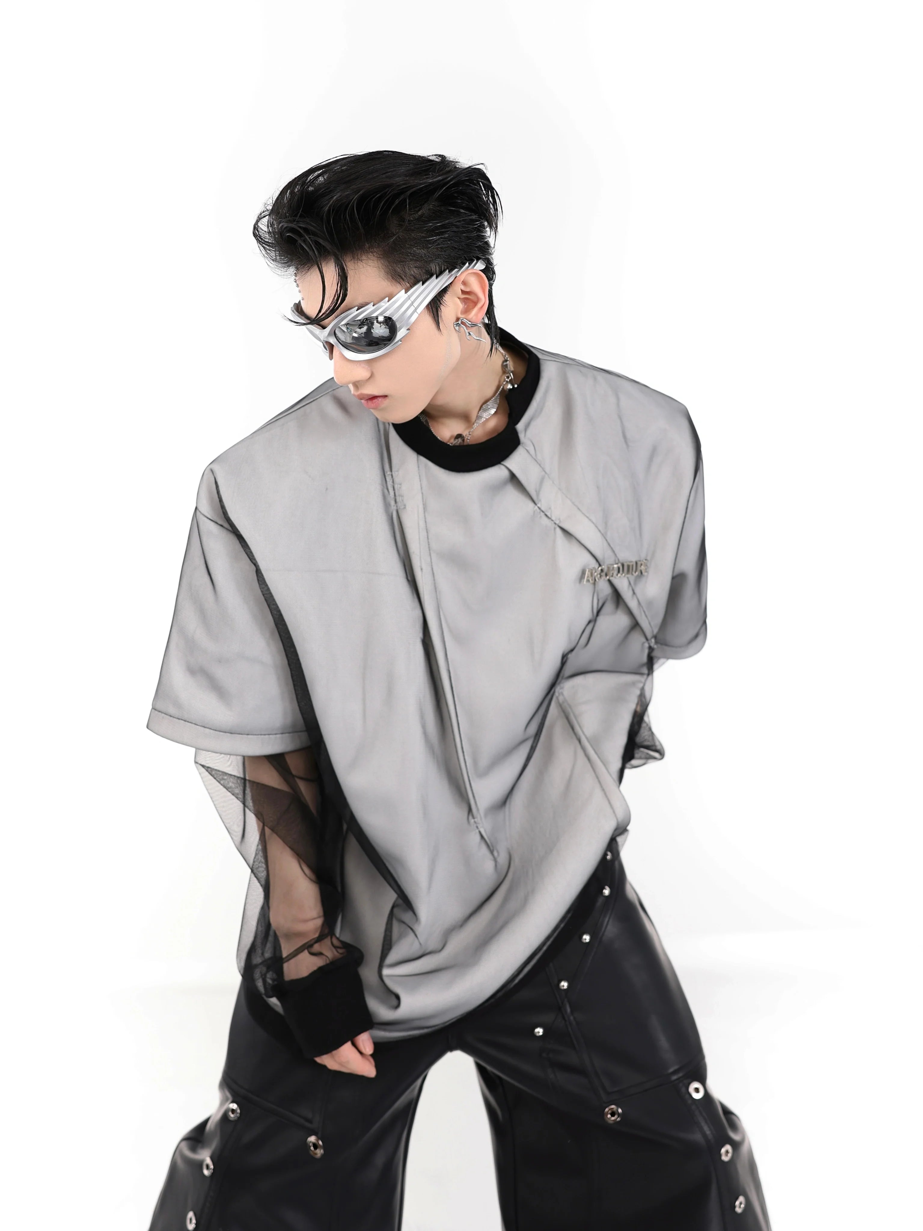 Oversized streetwear t-shirt with white base and black mesh overlay, showing urban fashion style