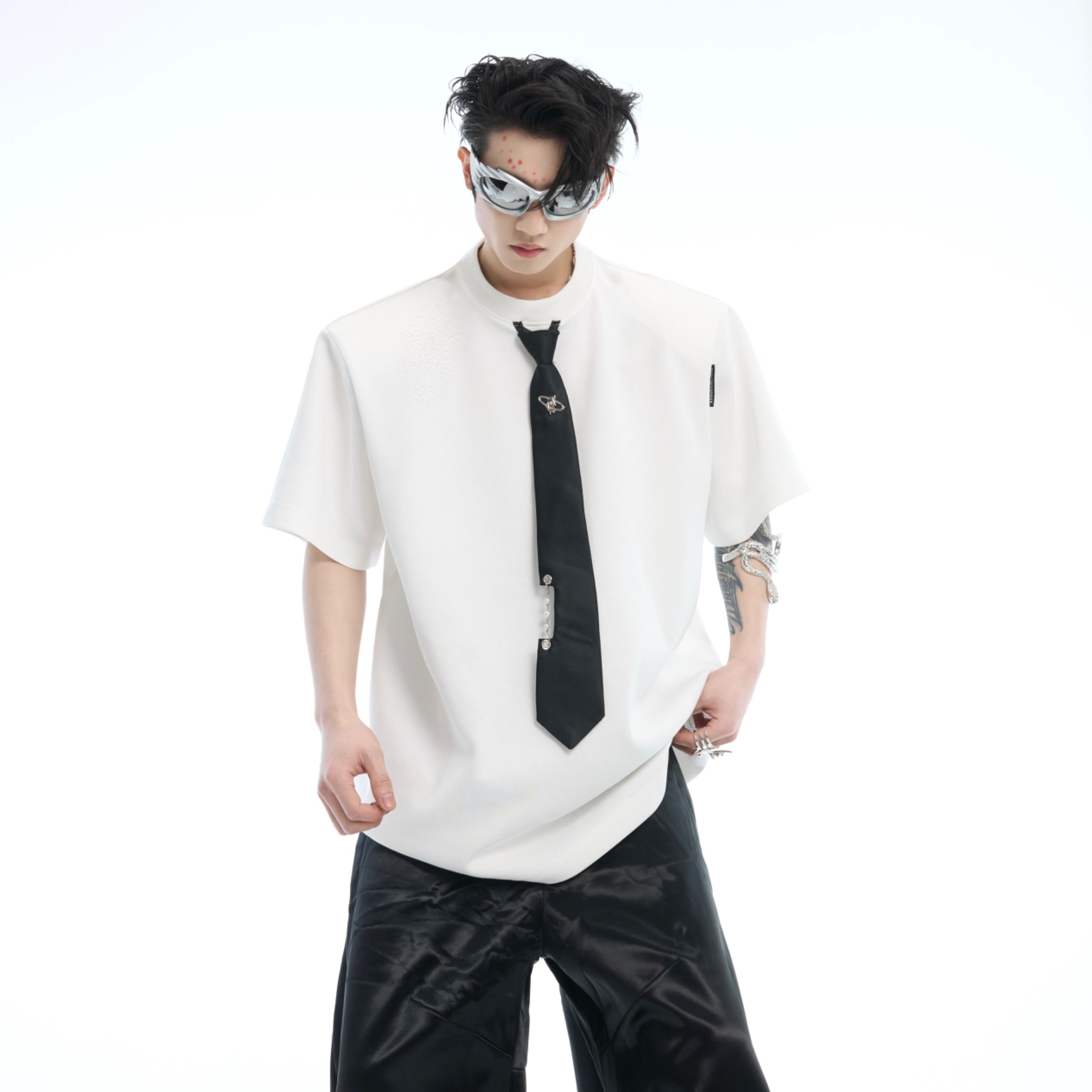 Model wearing oversized streetwear tee showing relaxed dropped shoulder cut and urban silhouette with tie accents