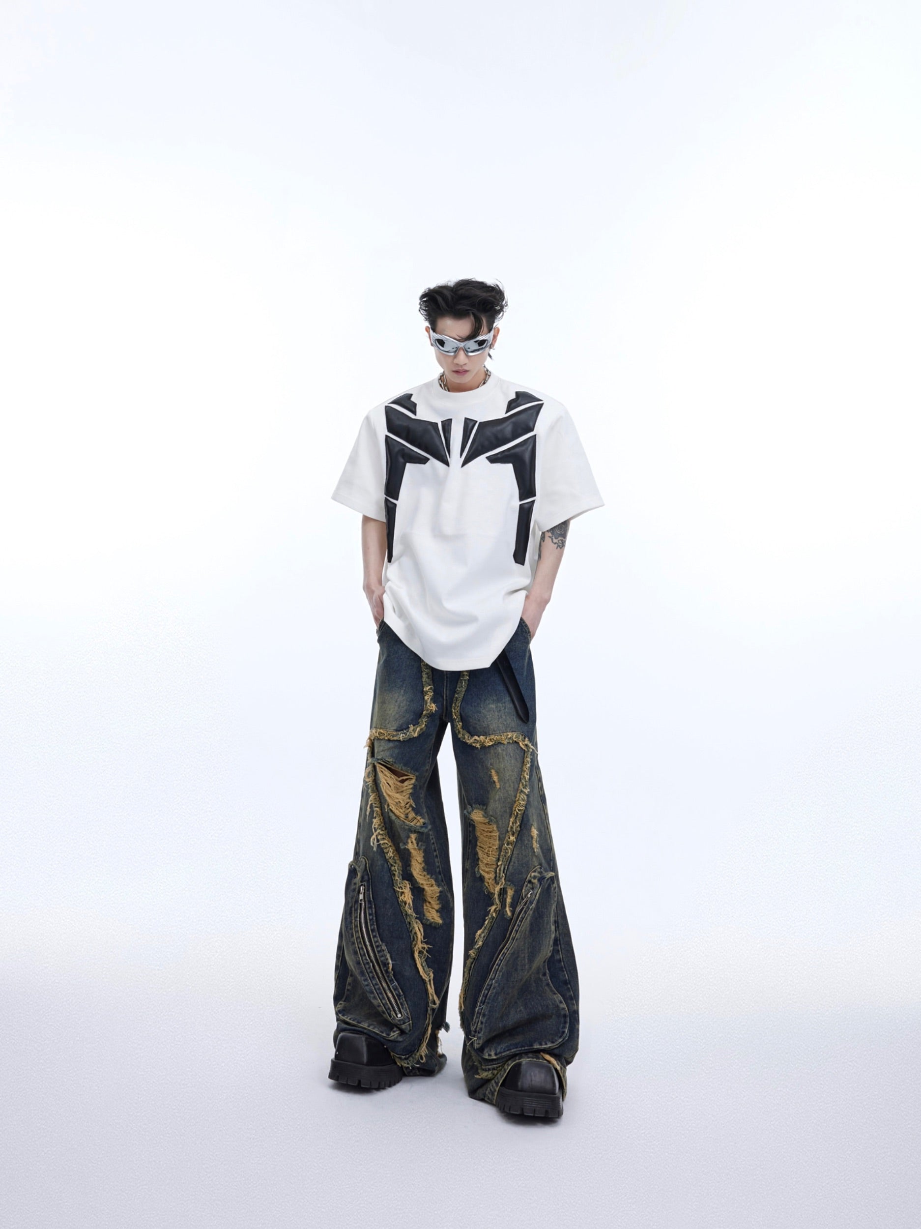 Streetwear tee with dramatic padded shoulders and deconstructed PU leather sleeve construction