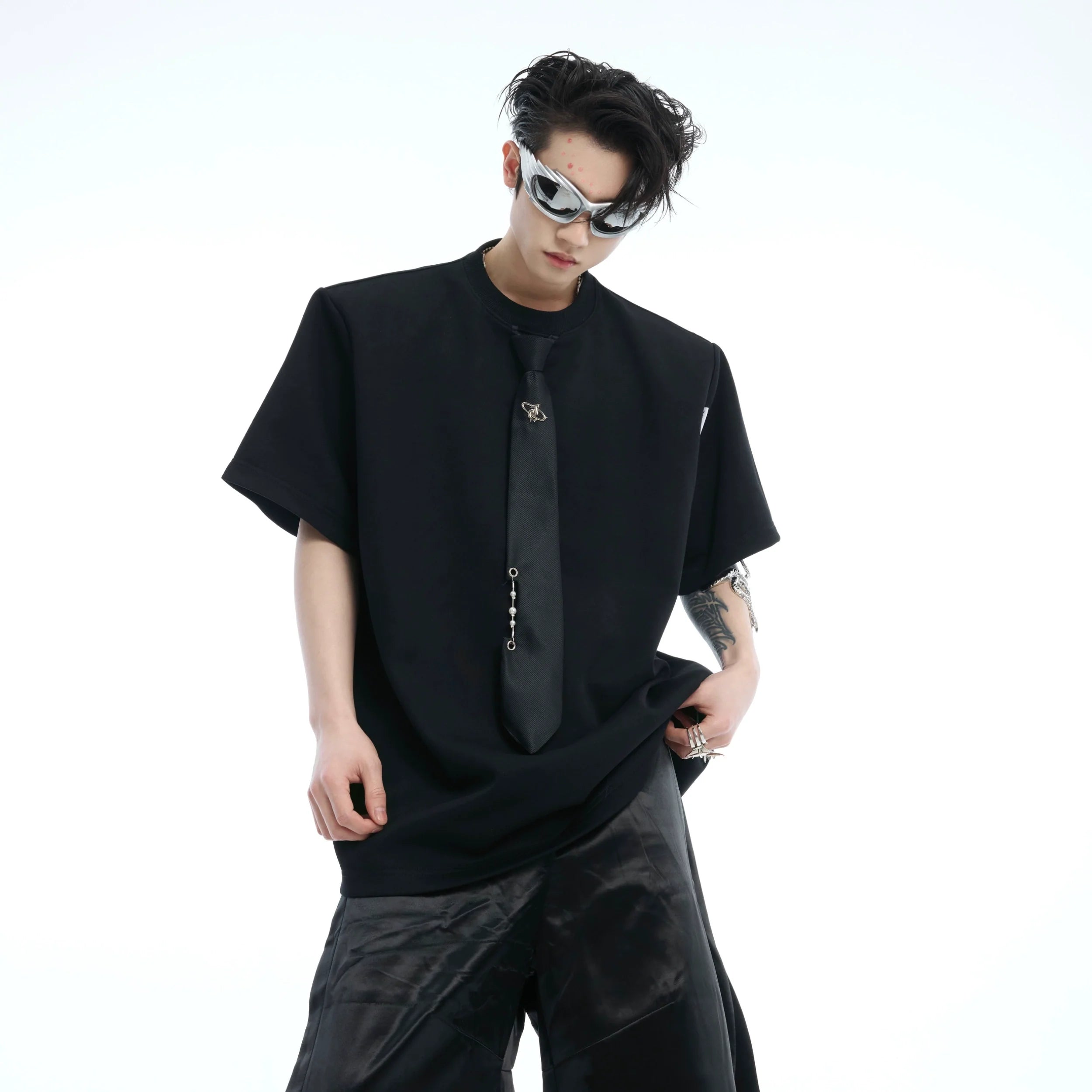 Front view of oversized graphic tee featuring unique tie-dye patchwork design and statement necktie detail for streetwear style