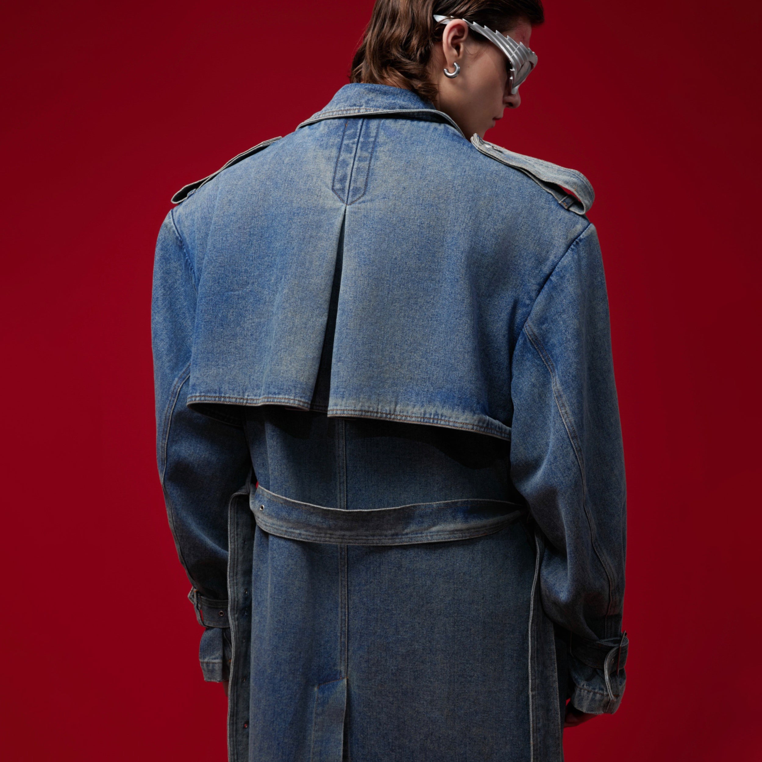 Side view of long denim coat featuring deconstructed vintage style and rugged motorcycle jacket elements