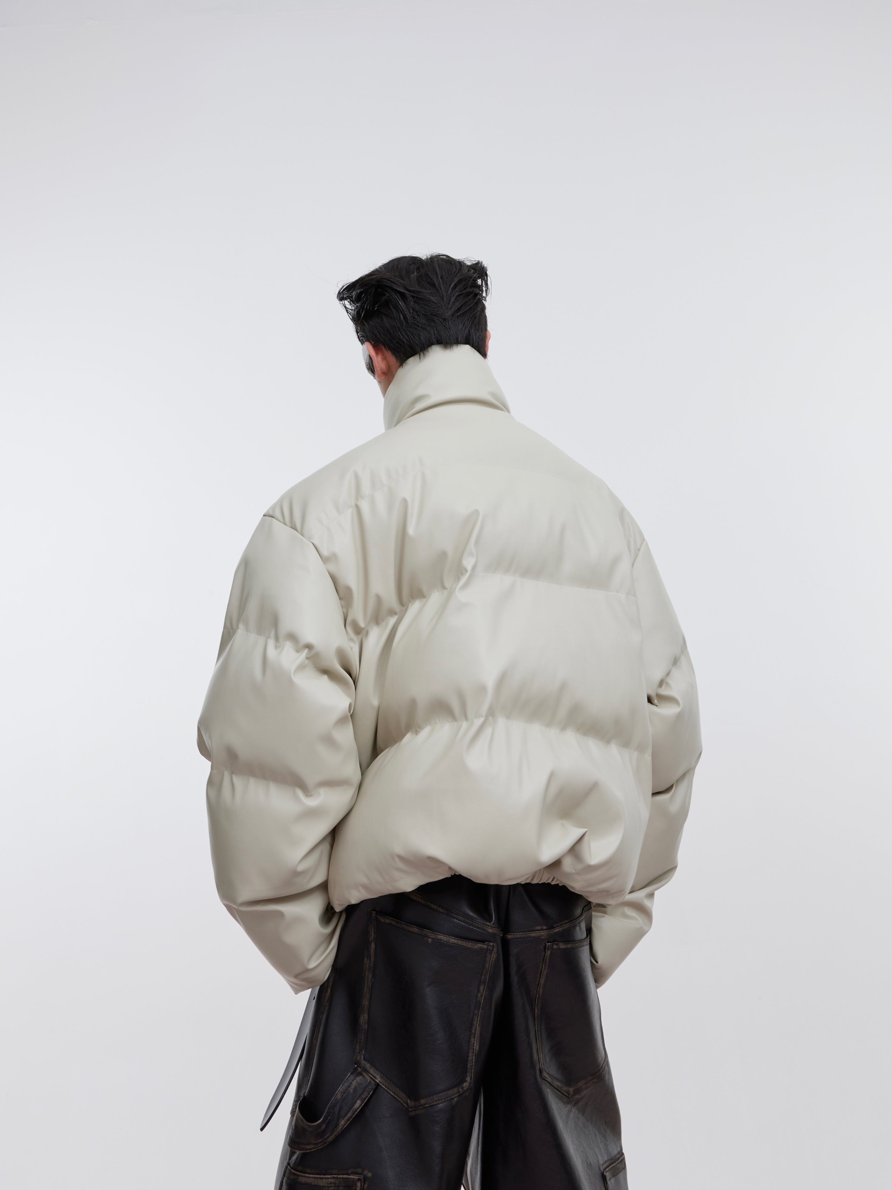 Closeup of unique back panel design on this deconstructed winter jacket with metal hardware accents