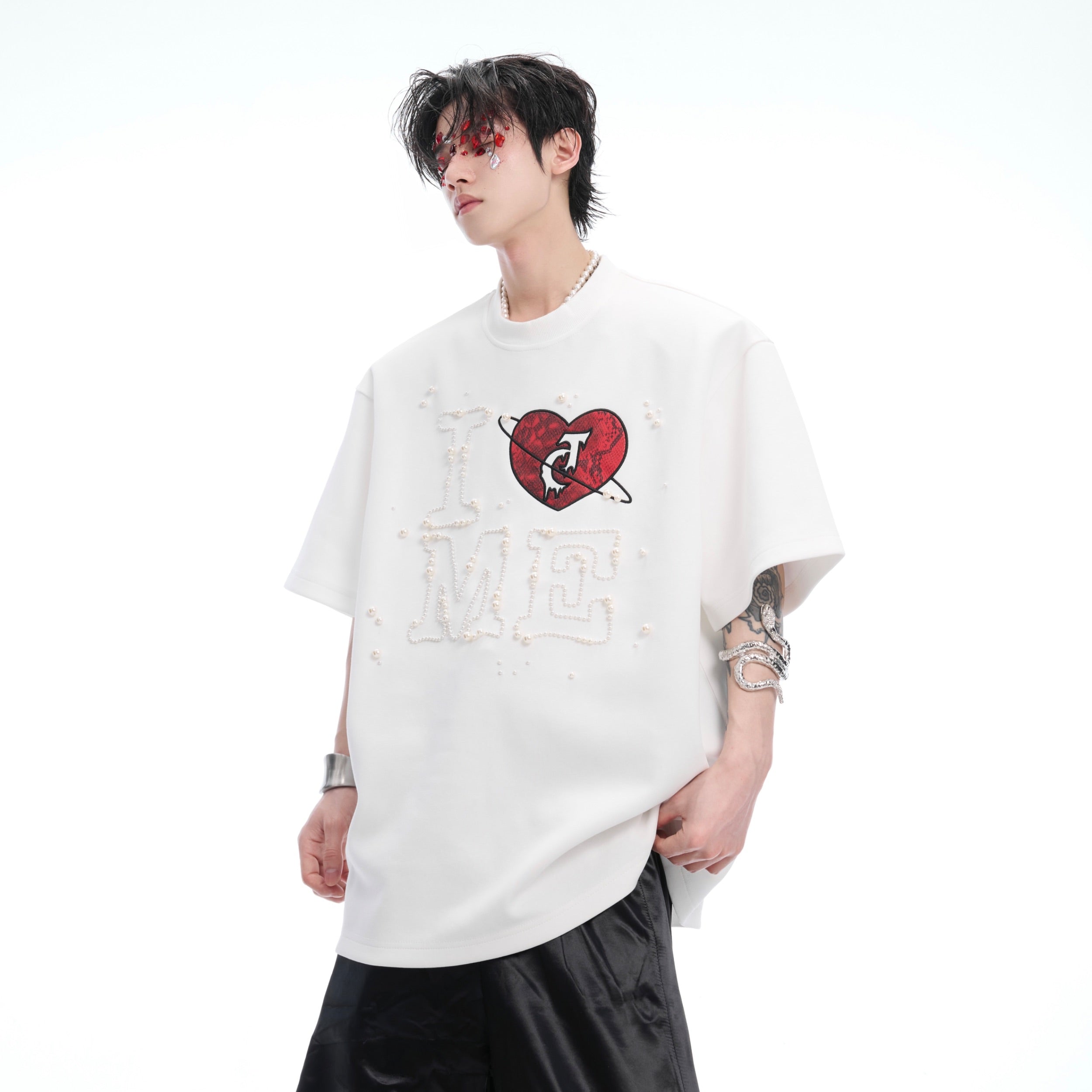 Front view of pearl-embellished heart graphic oversized tee with deconstructed streetwear design