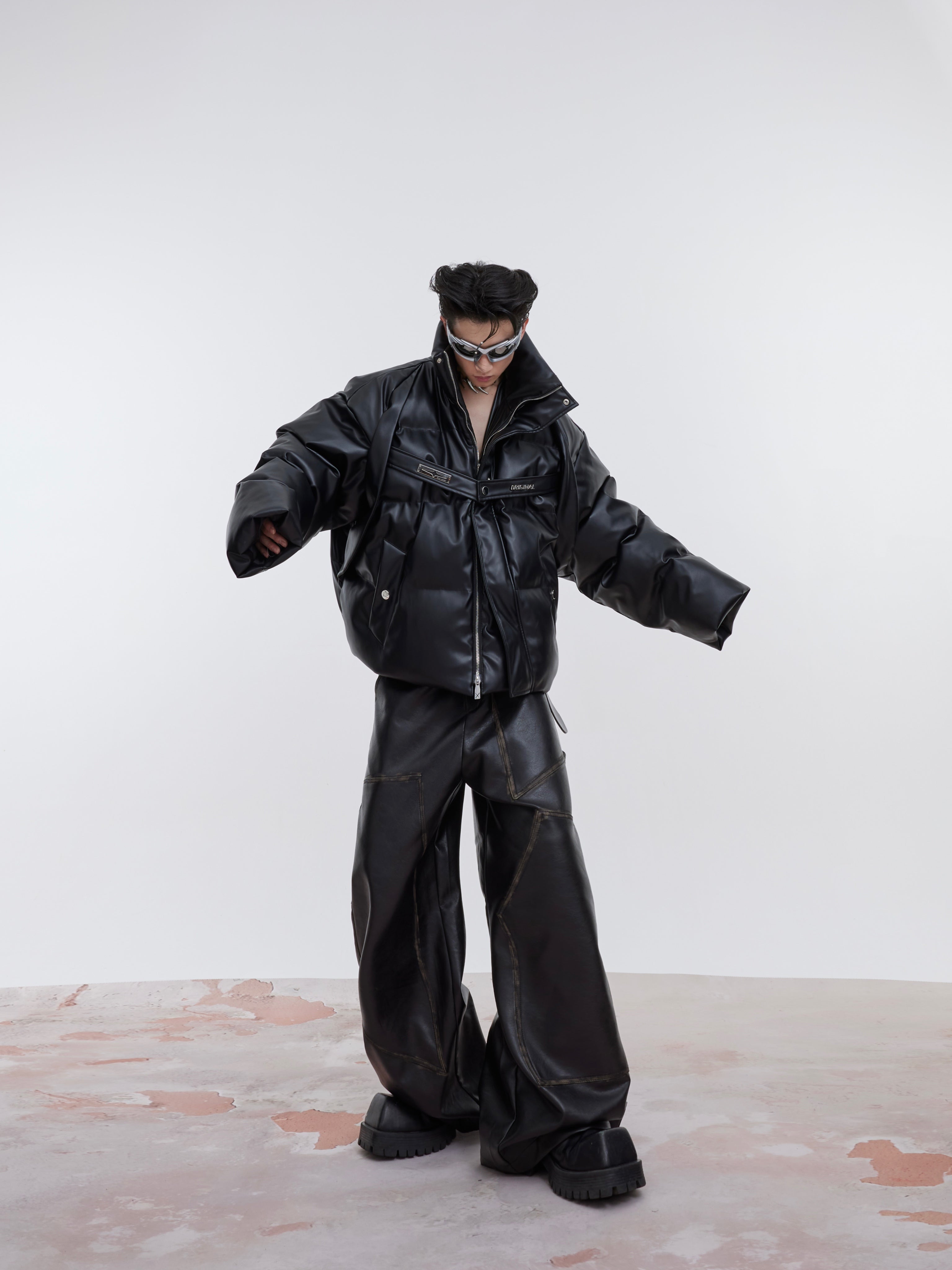 Detailed view of metal straps and zipper features on this contemporary padded streetwear jacket