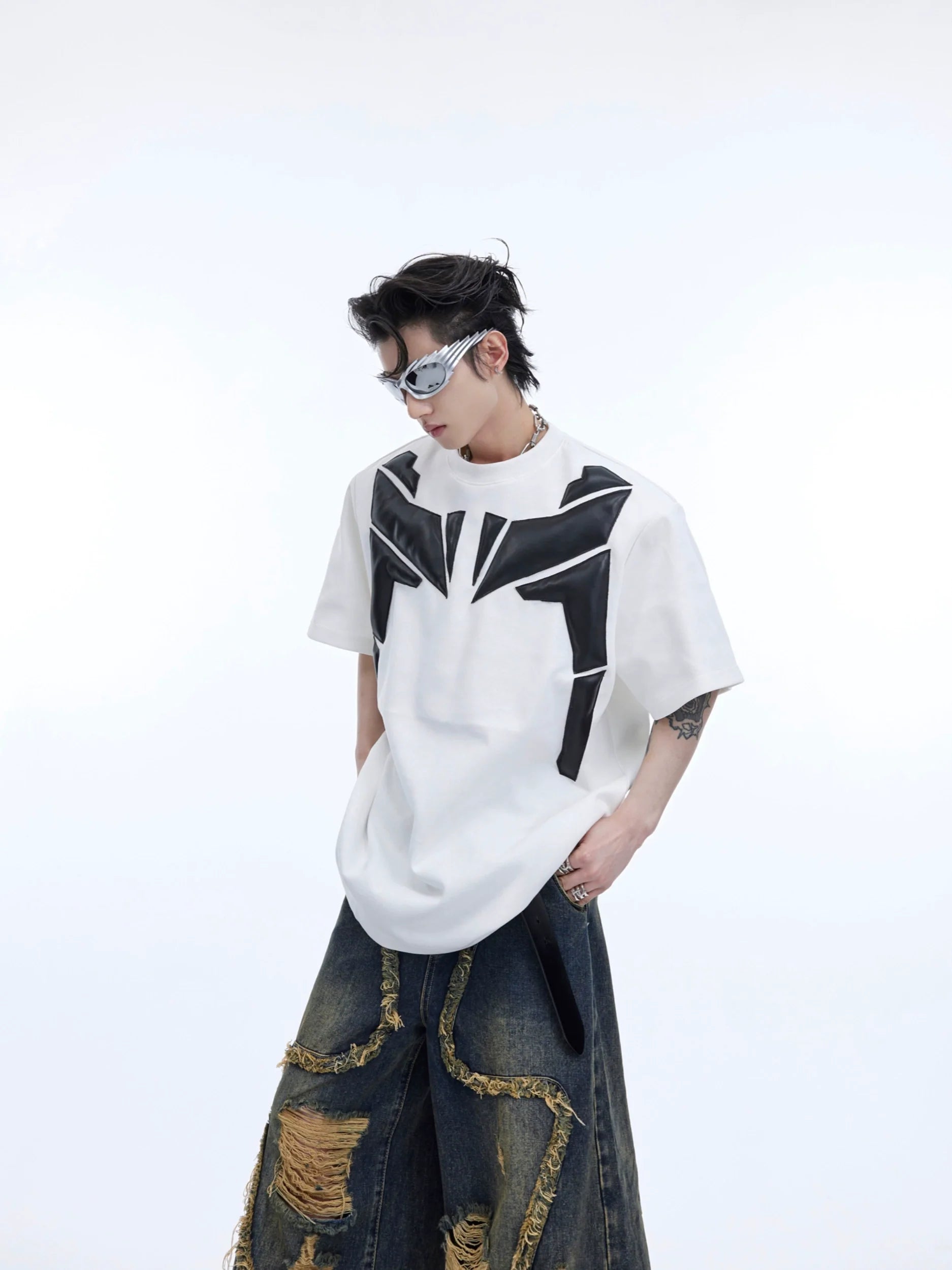Deconstructed oversized tee with 3D relief design and PU leather sleeves, featuring padded shoulder streetwear style