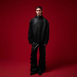Side view of oversized PU leather hoodie showcasing unique ink-wash pattern and dropped shoulders
