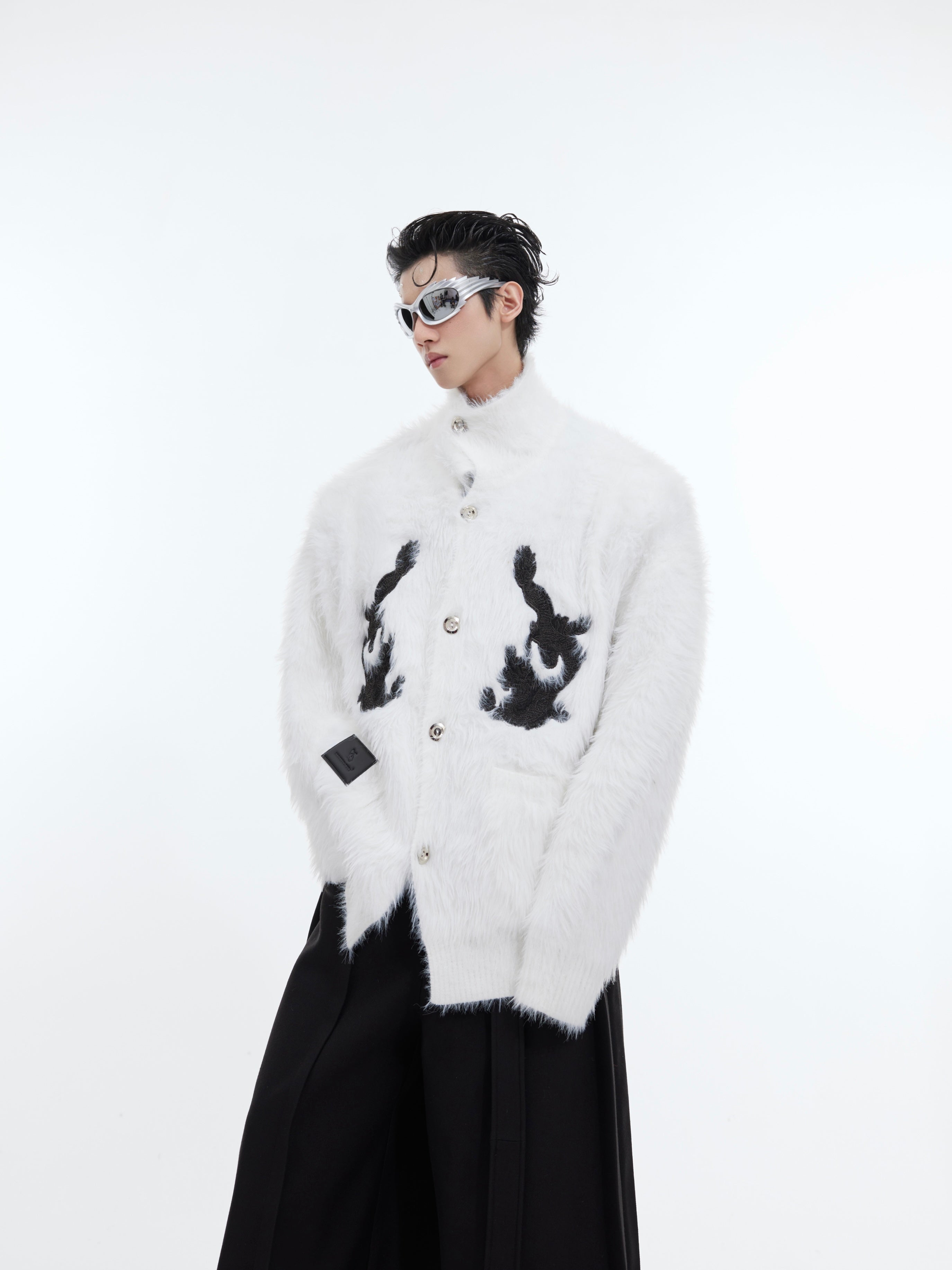 Side view of red plush knit cardigan showing unique patchwork deconstructed design details