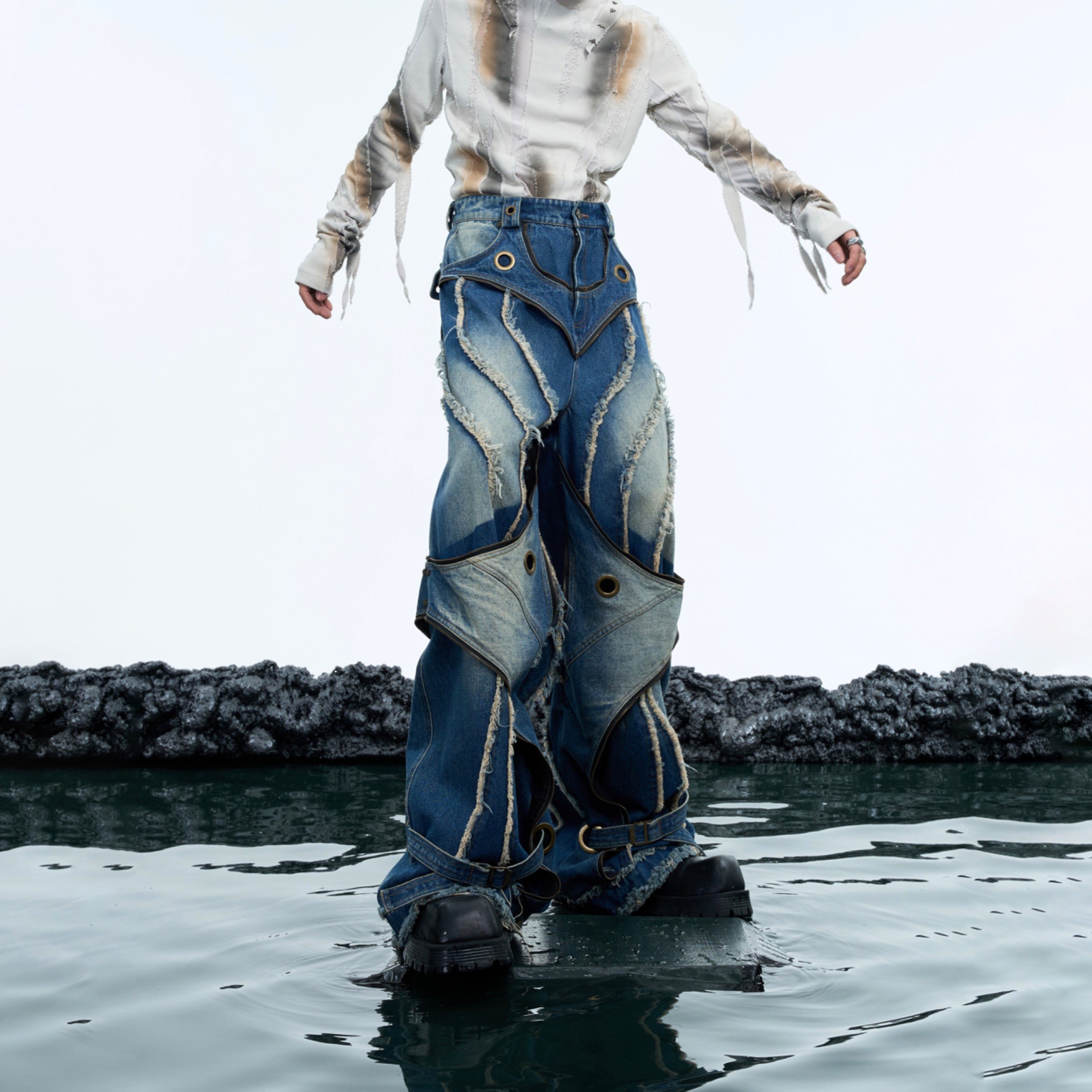 Side profile of distressed retro jeans highlighting the double-layer construction and raw hem design