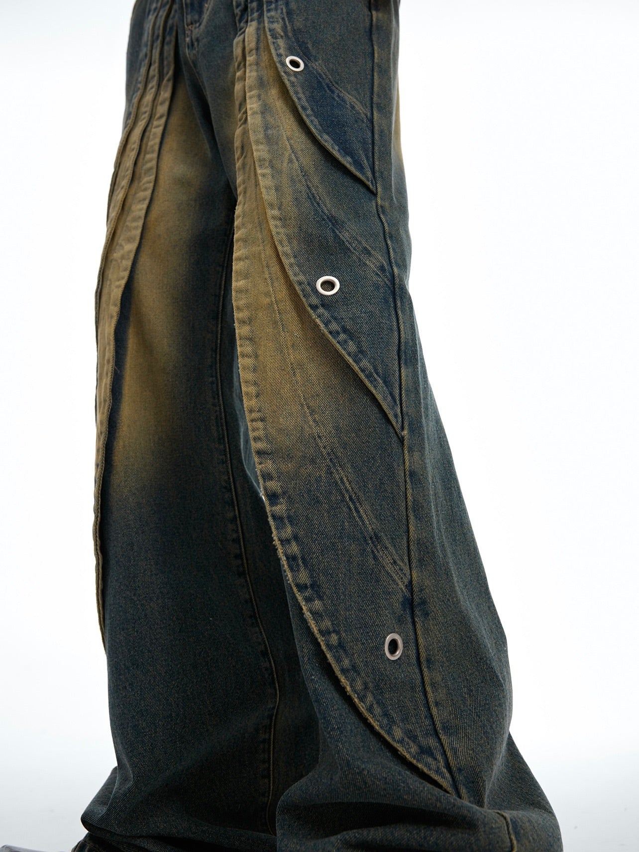 Detailed shot of the artfully ripped stitching and distressed details on these premium soft denim jeans