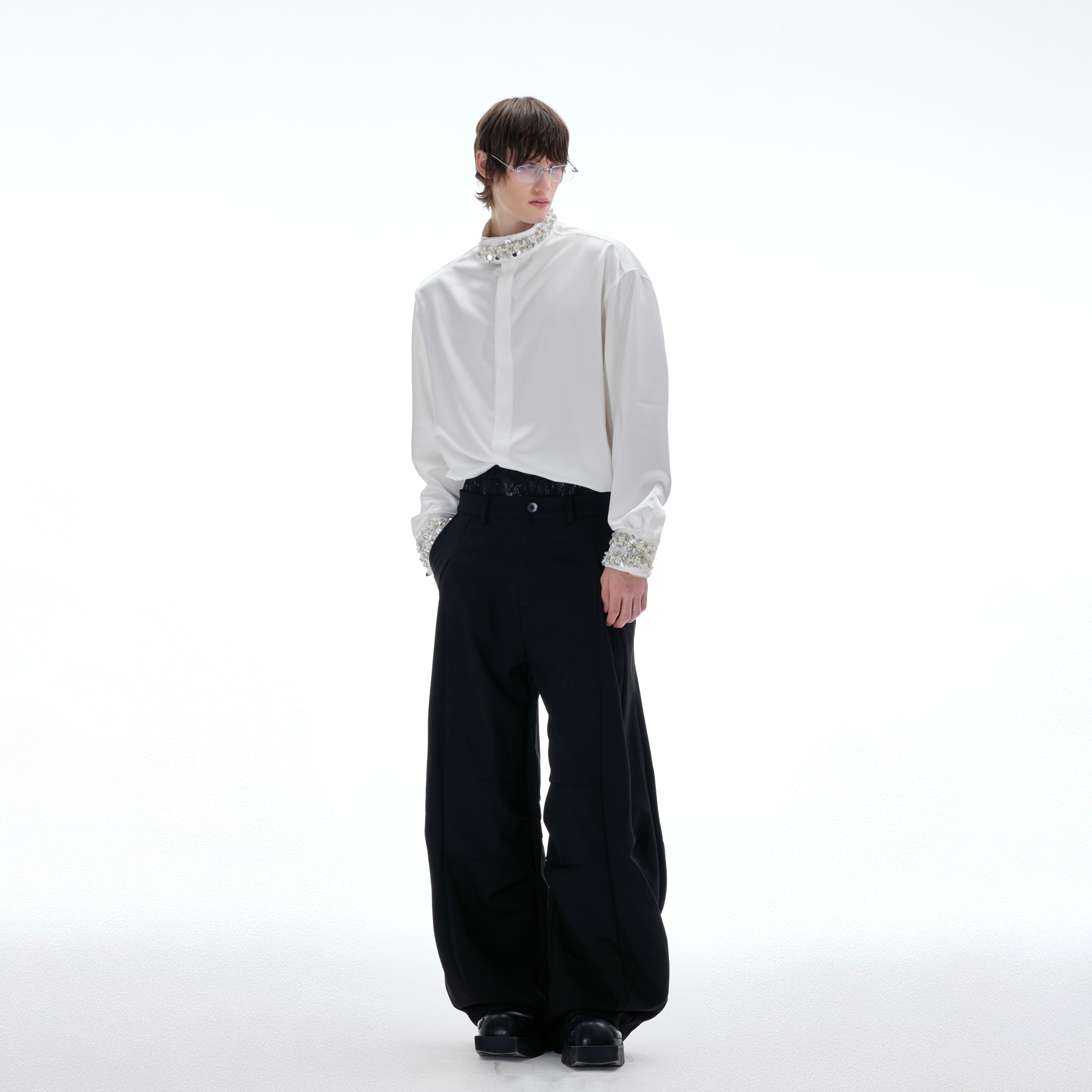 Close-up of hidden snaps on detachable shoulder pads of luxury satin shirt with diamond trim