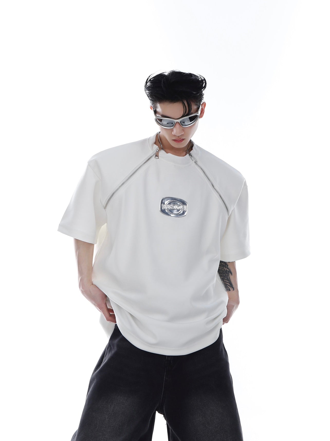 Back view of the gender-neutral zip-up tee showing sharp lines and bold metal trim accents