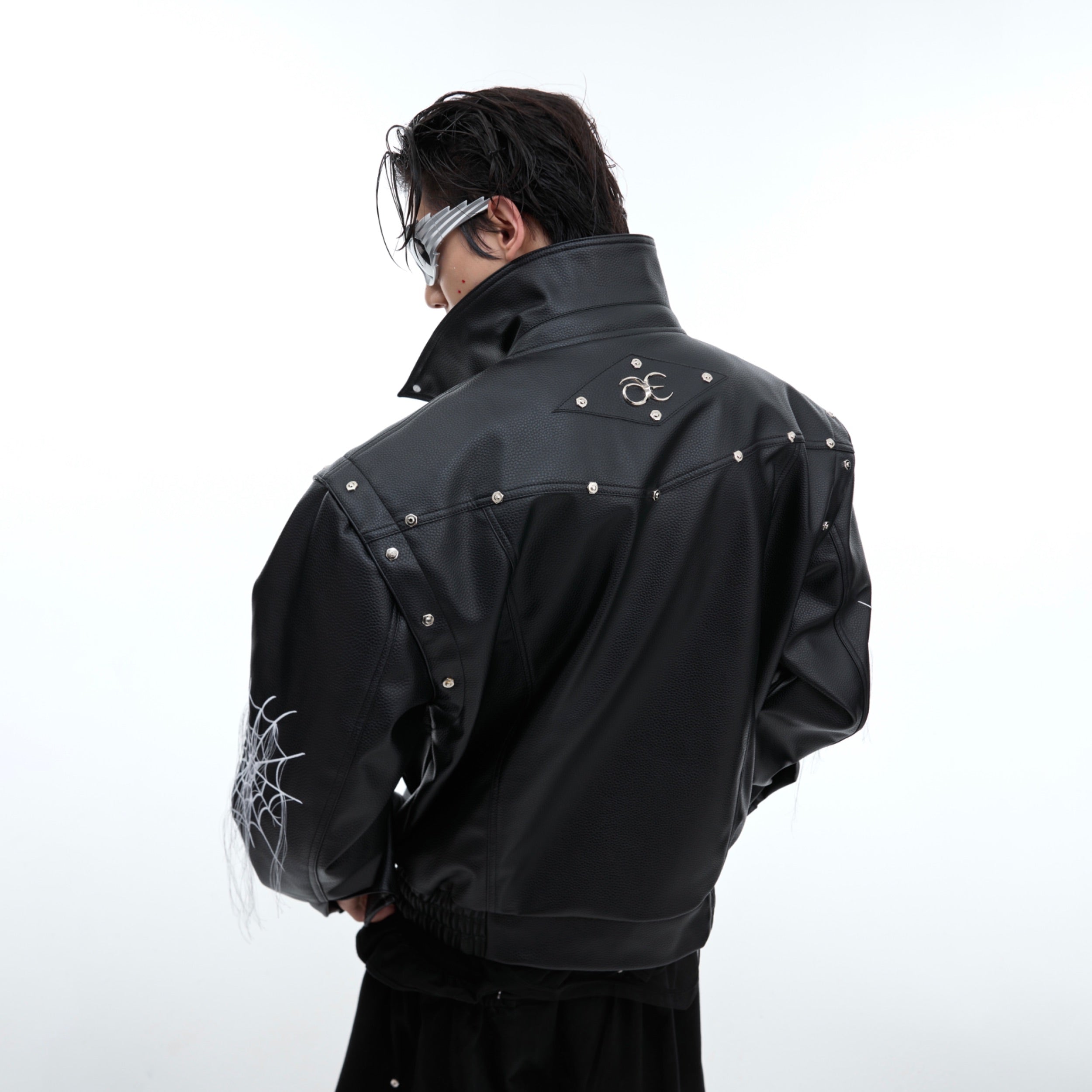 Back view of unique punk leather jacket showing intricate spiderweb fringe detailing and metal stud embellishments