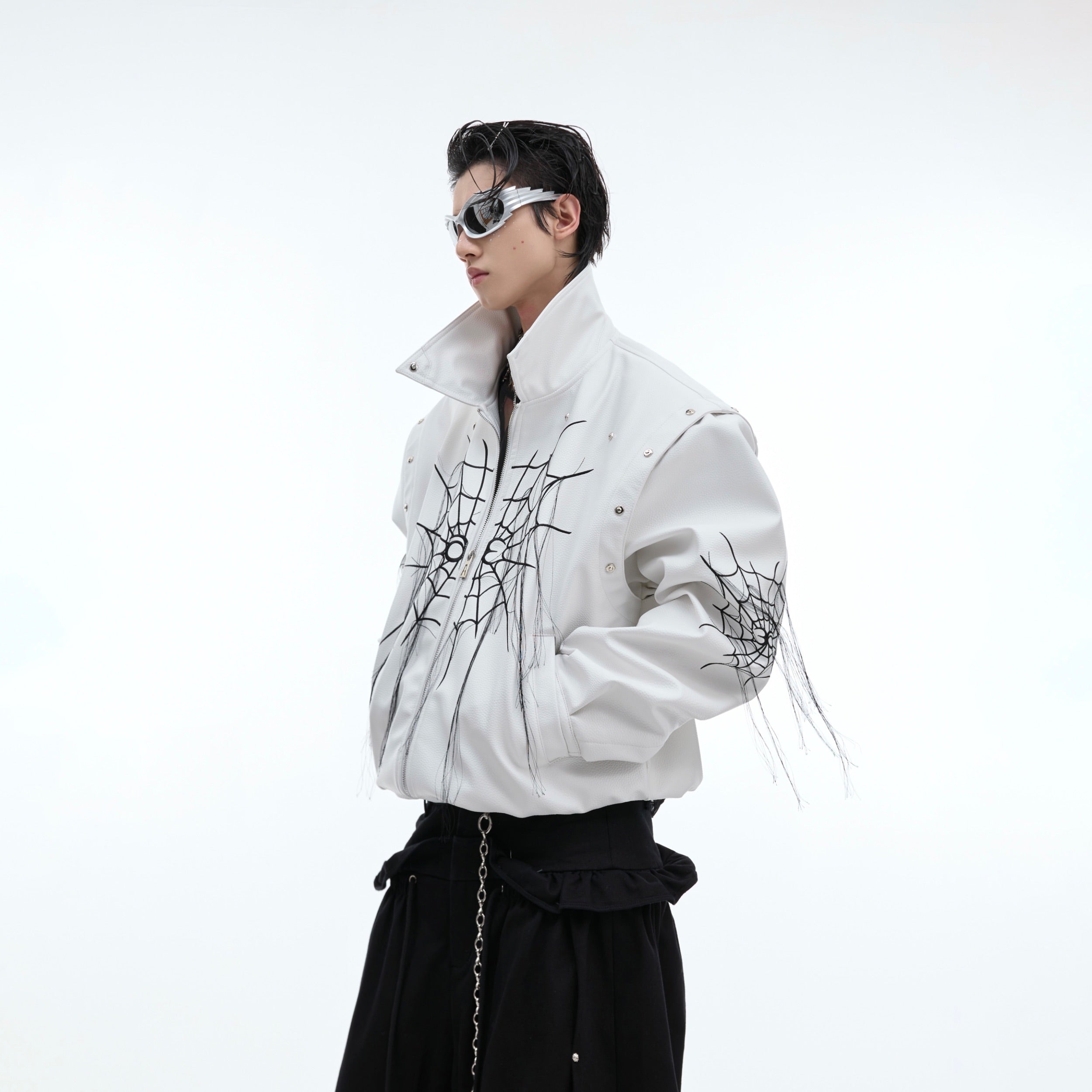 Close-up detail of metal studs and spiderweb fringe on this statement-making punk leather jacket