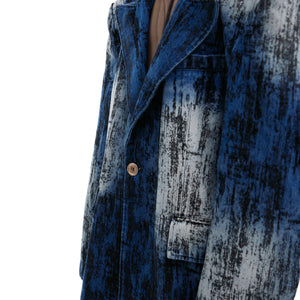 Close-up of irregular spray-dye pattern on sand-washed denim creating vintage distressed effect