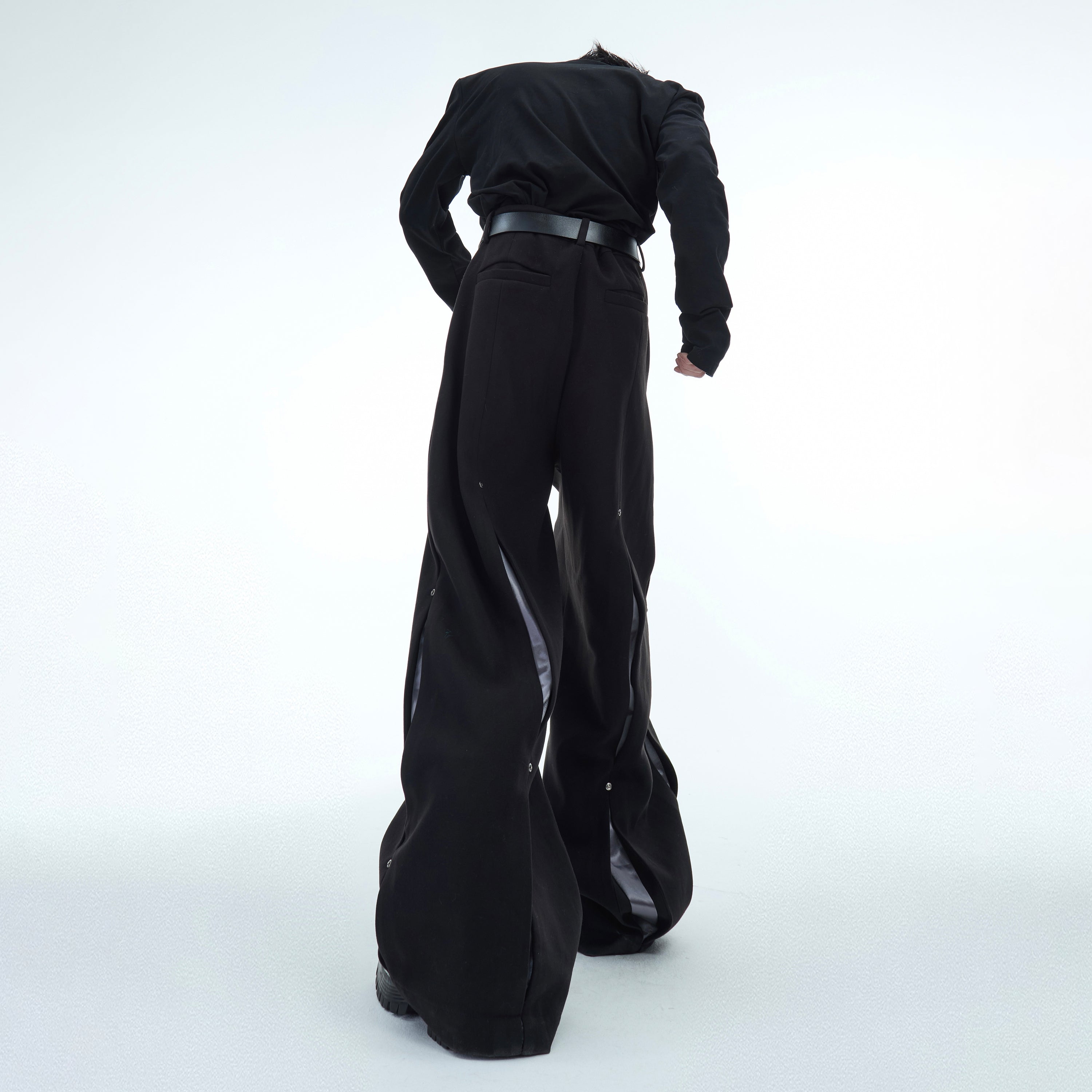 Back view of high-fashion deconstructed pants with minimalist tailoring for urban looks