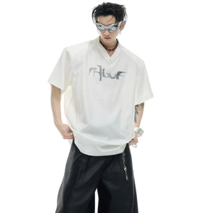 Close-up of reflective metallic logo on deconstructed oversized t-shirt with V-neck design