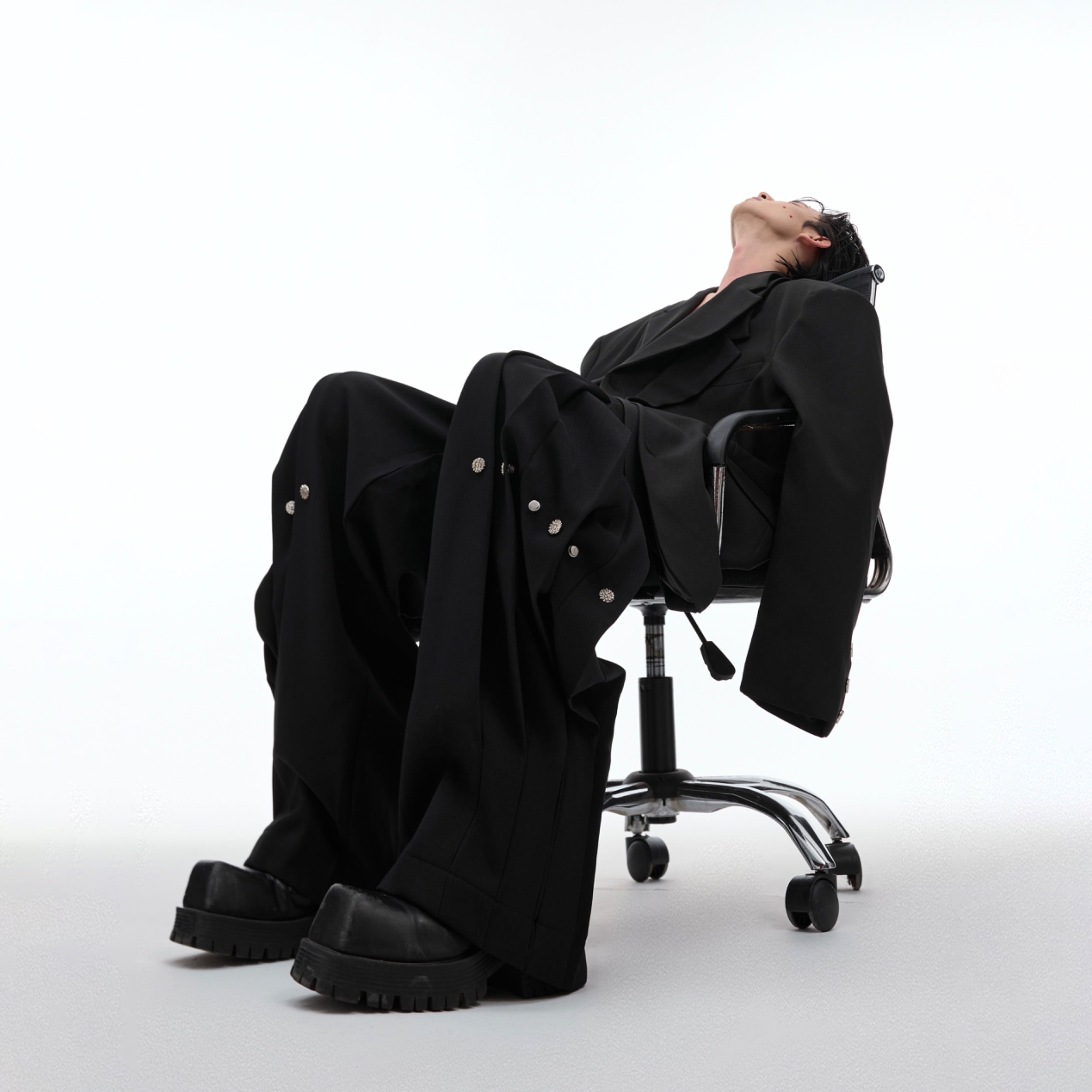 Side profile view of streetwear trousers showing unique deconstructed panel construction
