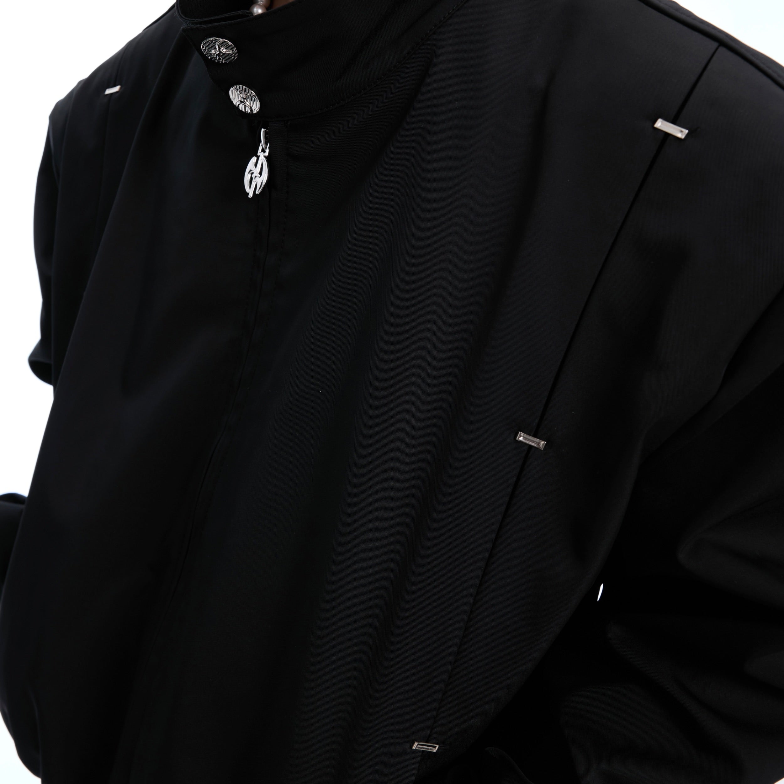 Side profile of studded collar Harrington jacket showing architectural silhouette and premium fabric
