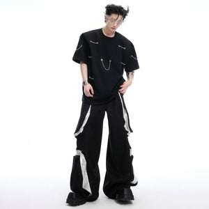 Flat lay style shot of black statement t-shirt with chunky chain detailing and shoulder pads