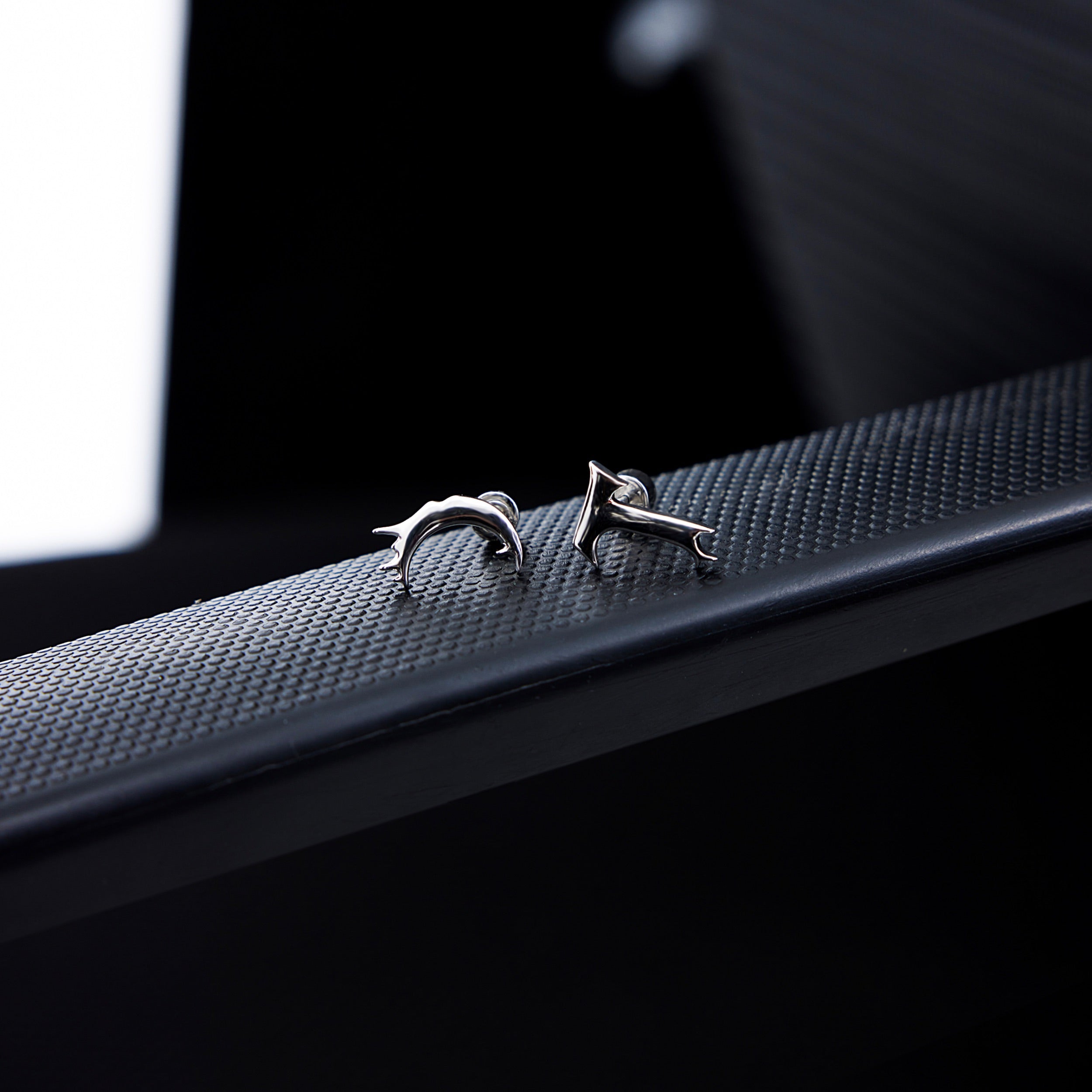 Detailed shot of premium quality T-shaped earrings highlighting the intricate deconstructed metal work