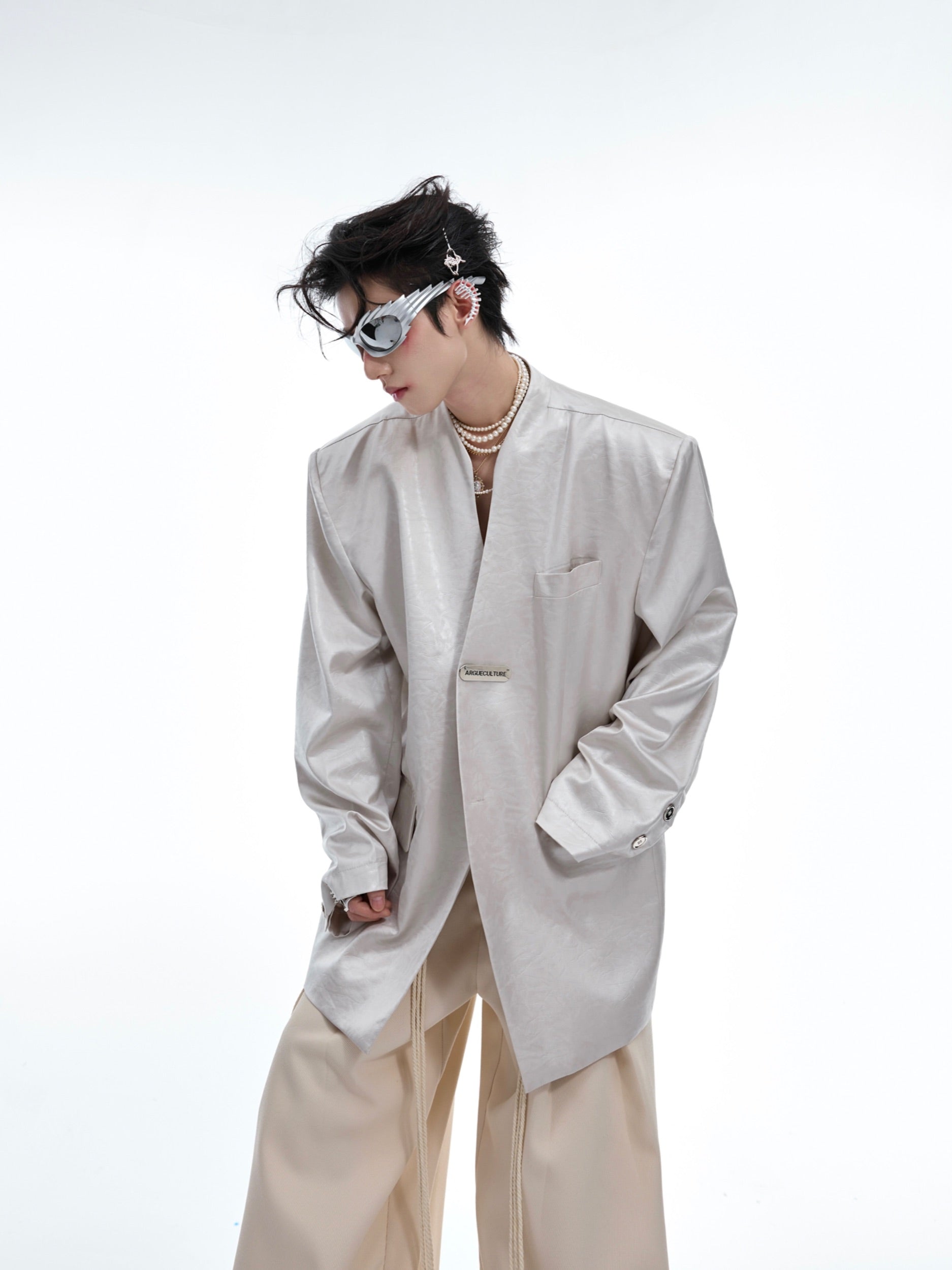 Close-up of premium liquid metal textured fabric and deconstructed detailing on luxury streetwear blazer