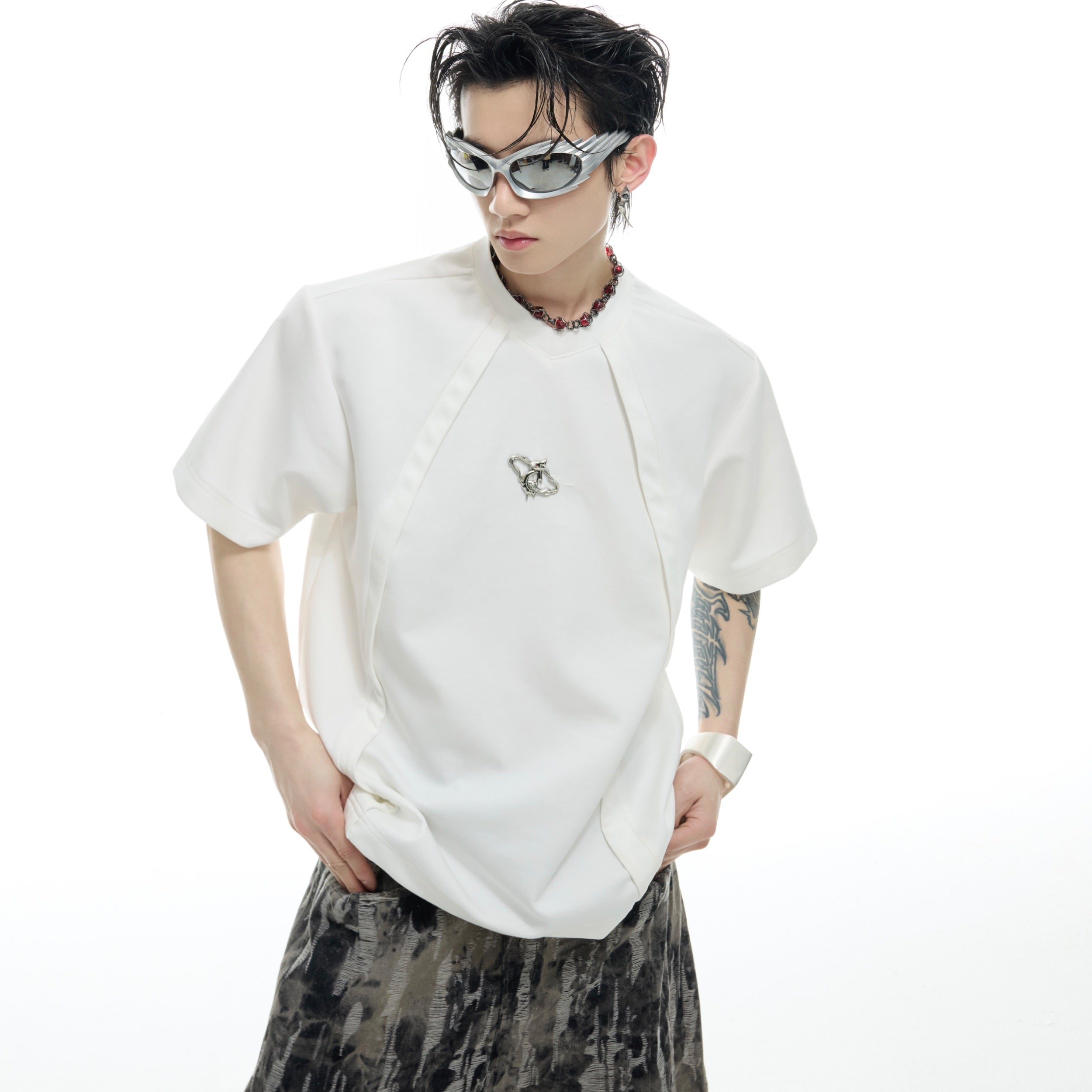 Detailed close-up of the 3D segmented metal logo on urban style oversized t-shirt
