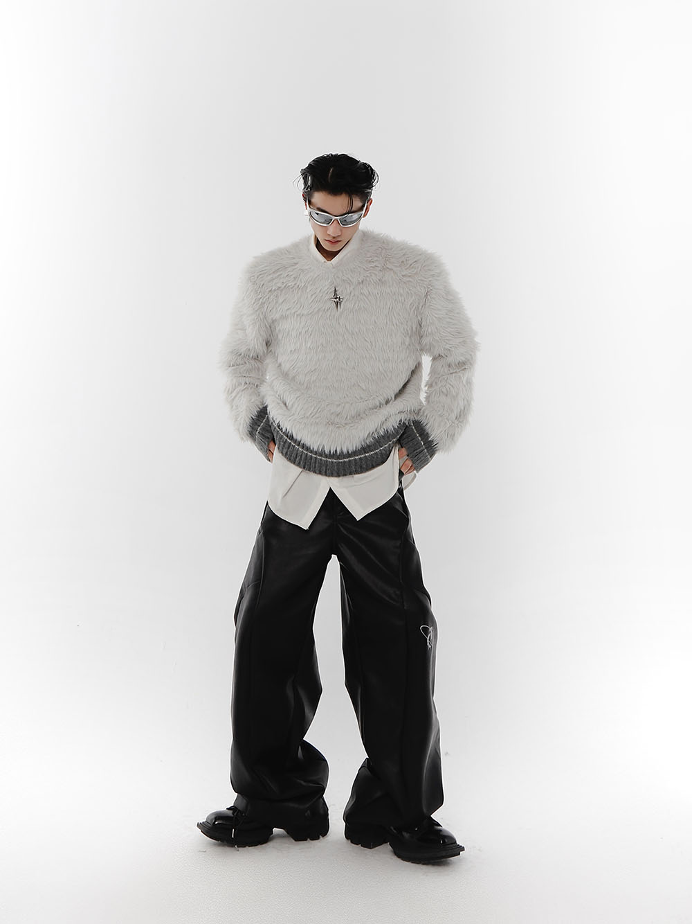 Slim-fit model wearing unisex chunky knit streetwear sweater with metal accents