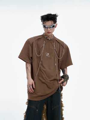 Distressed shoulder pads with metal chains on vintage oversized streetwear t-shirt, punk fashion statement