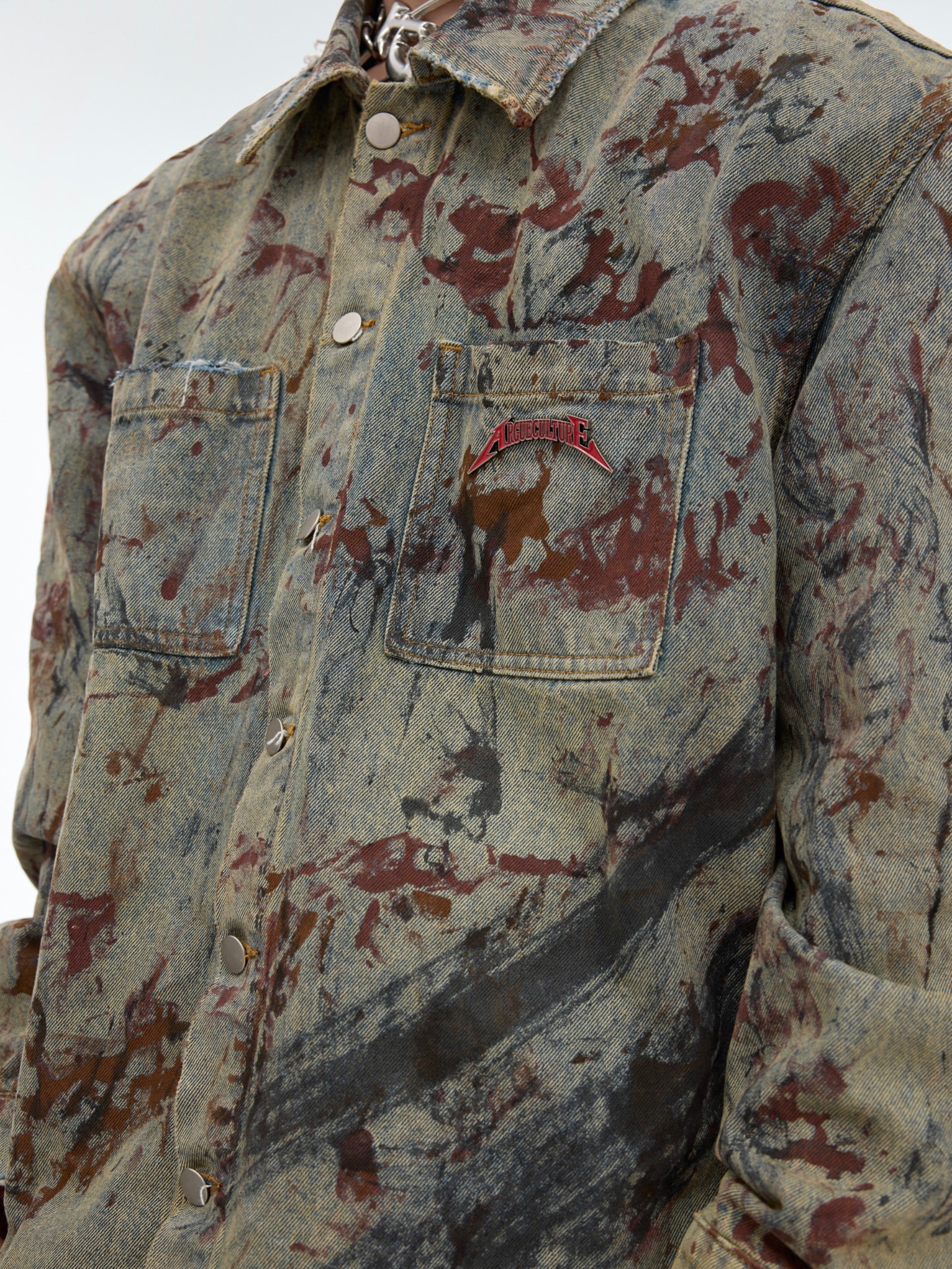 Back view of vintage denim jacket with artistic spray paint designs and intentional distressing details