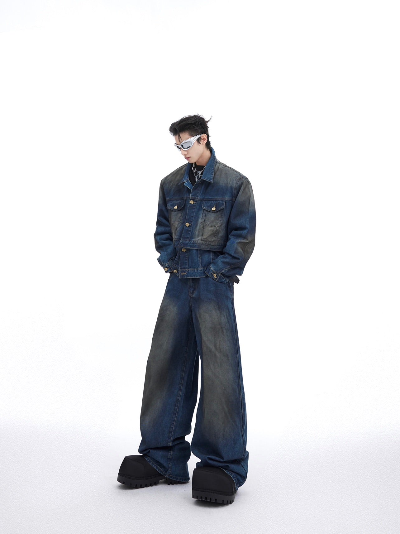 Front view of vintage distressed denim jacket with raw edges and deconstructed details, paired with baggy pants