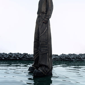 Vintage distressed denim jeans with relaxed flare fit showing artful distressing and heavy wash details