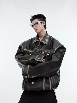 Vintage distressed leather jacket with avant-garde deconstructed panels and metal hardware accents, cropped biker style