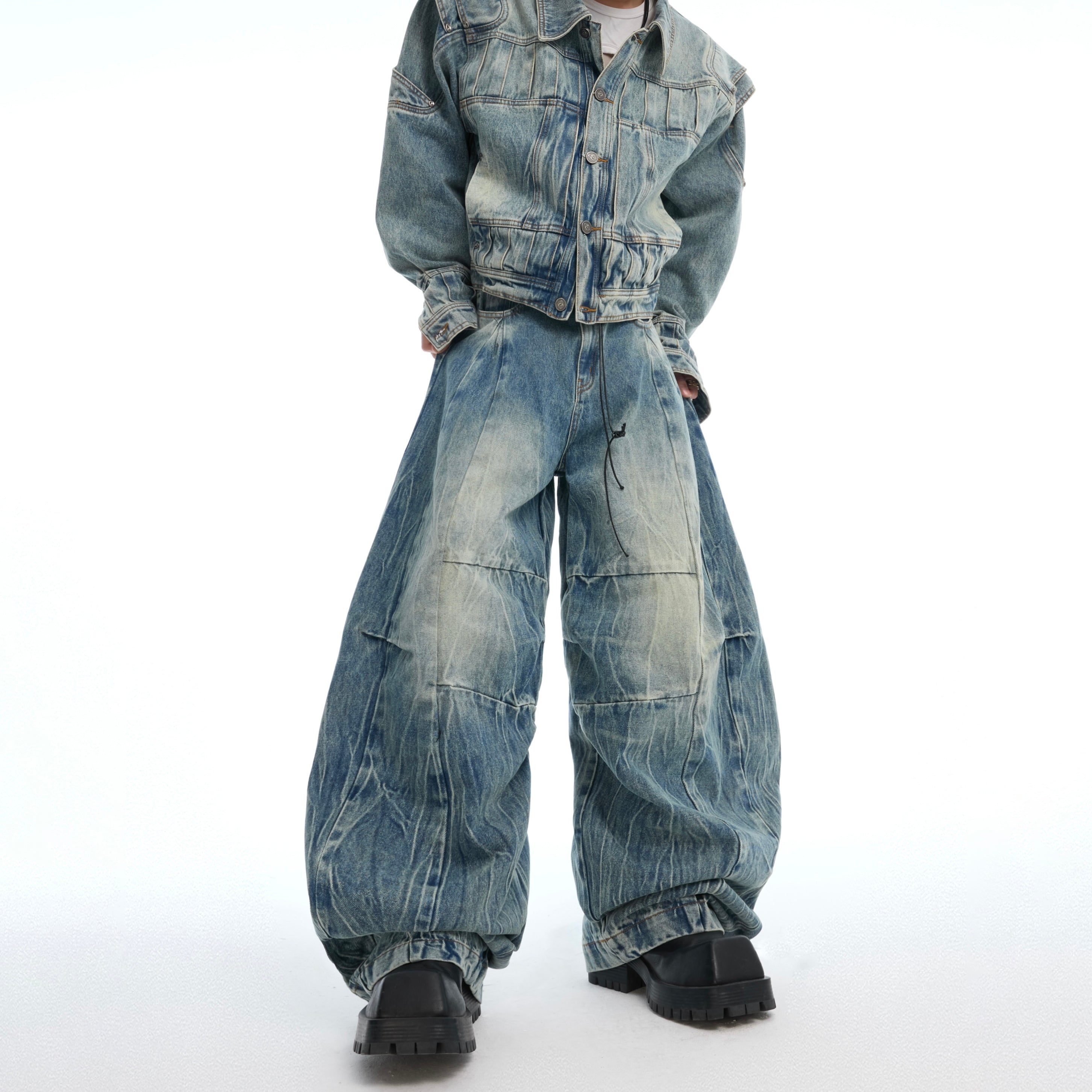 Model wearing distressed deconstructed jeans with muddy vintage wash, showing relaxed baggy fit