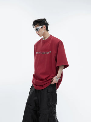 Vintage washed cotton tee with drop shoulder design, featuring a distressed metal logo for urban streetwear style