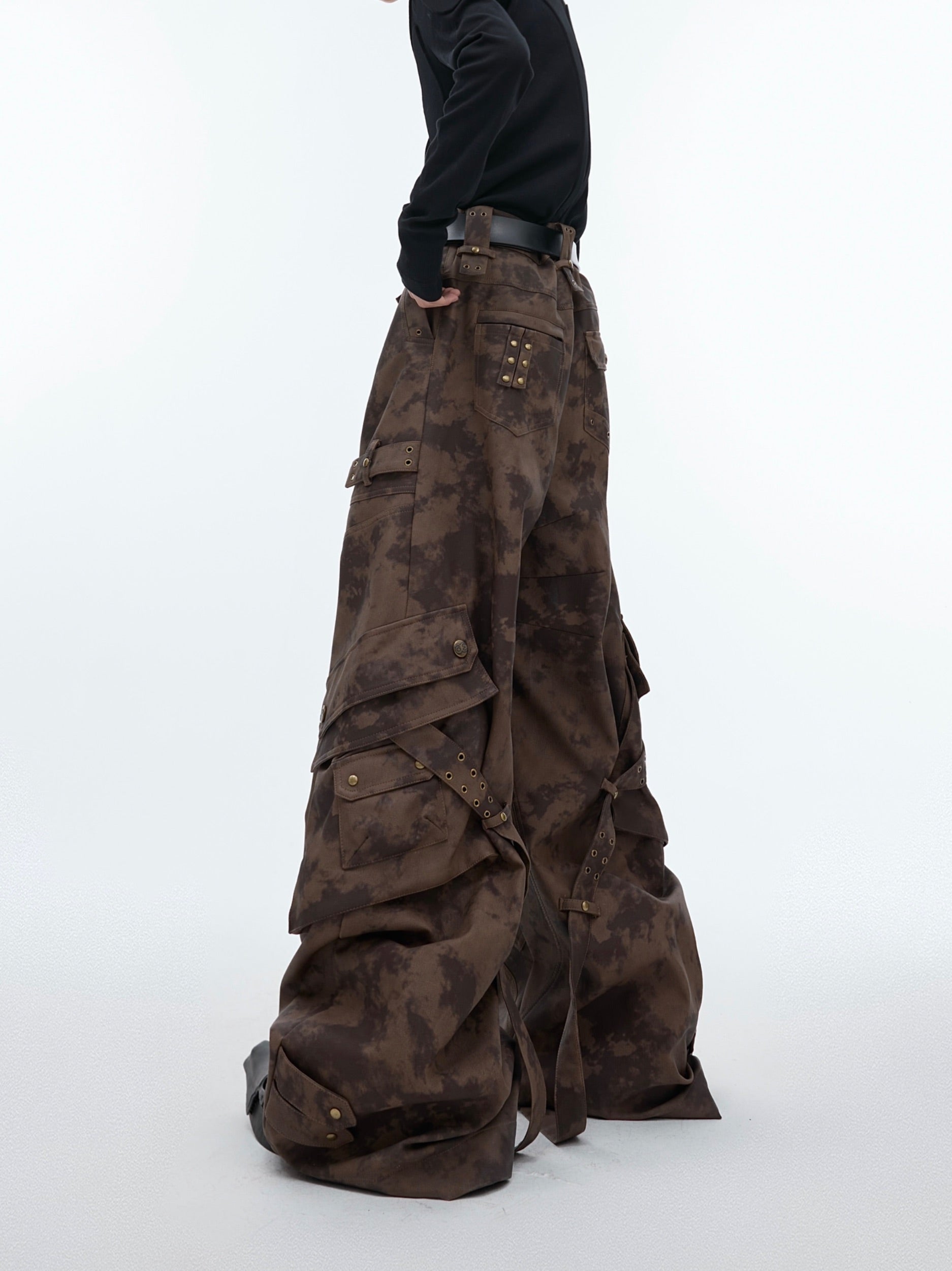 Close-up of metal button details on vintage washed cargo leather pants with distressed wide-leg design