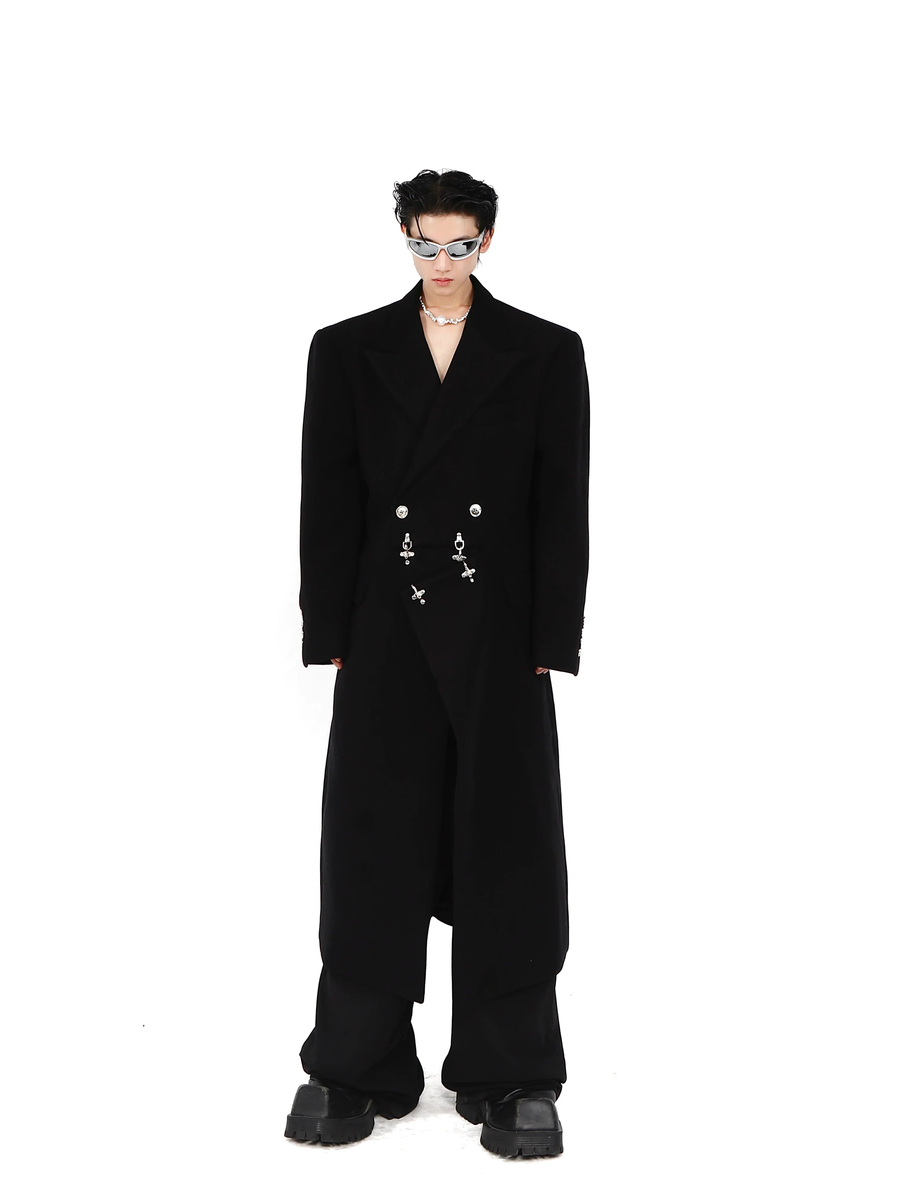 Deconstructed wool coat with prominent metal airplane buckle closure and shoulder pads, avant-garde streetwear fashion