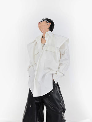 Close-up detail of the deconstructed pleated shirt's enhanced wide shoulder construction and premium fabric texture